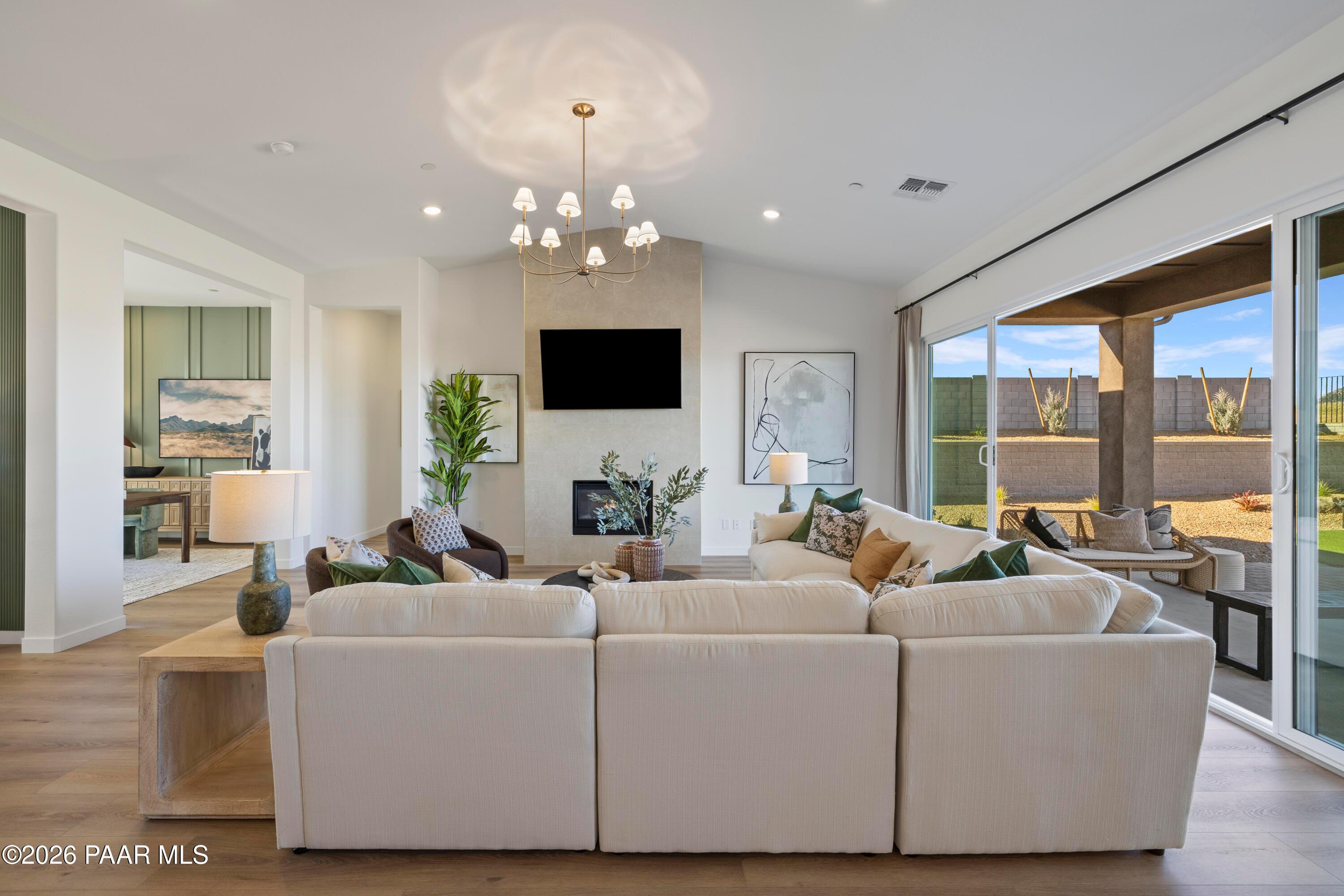 Open-concept living room with fireplace and sliding glass doors in The Blaze D floor plan at Hidden Hills, Prescott, AZ.