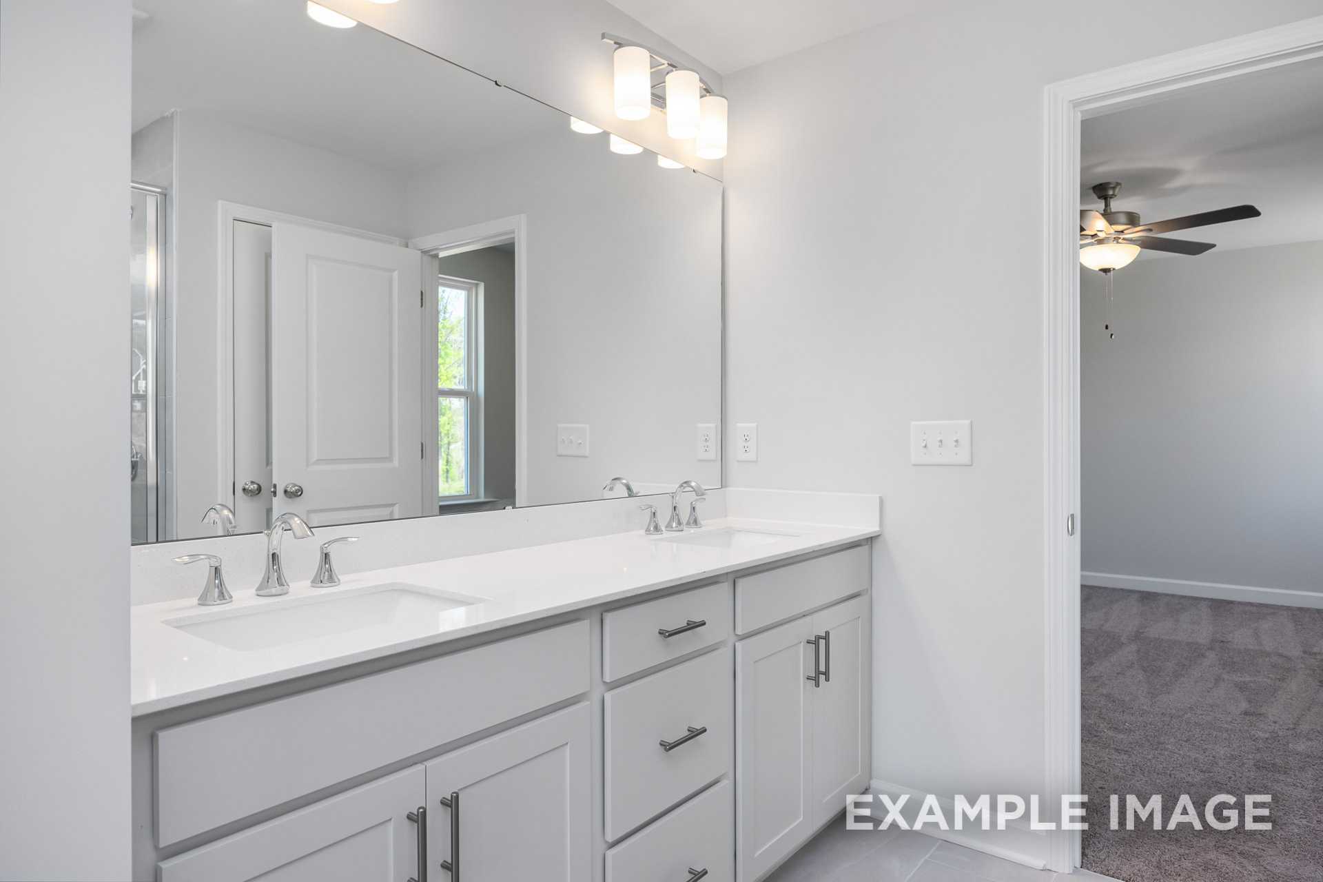 Spacious master bathroom in The Gavin C featuring white double vanity, large mirror, and pendant lights