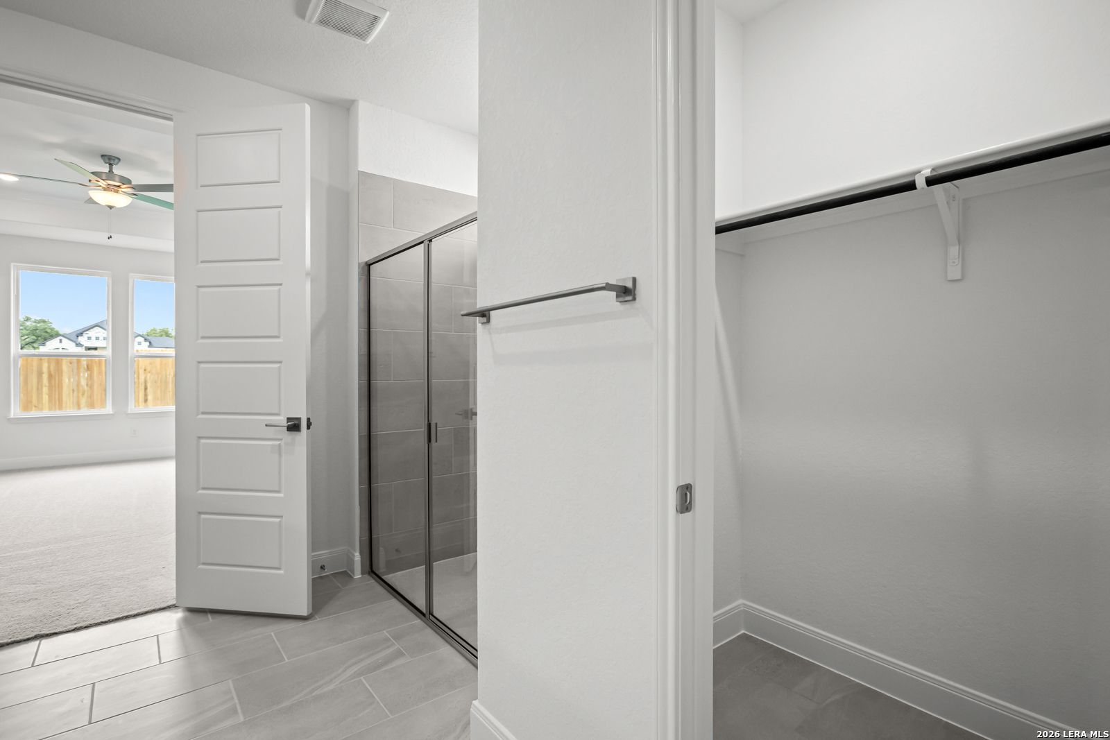 Walk-in closet and glass-enclosed shower in The Lanier G floor plan at The Reserve at Potranco Oaks, Castroville, Texas.