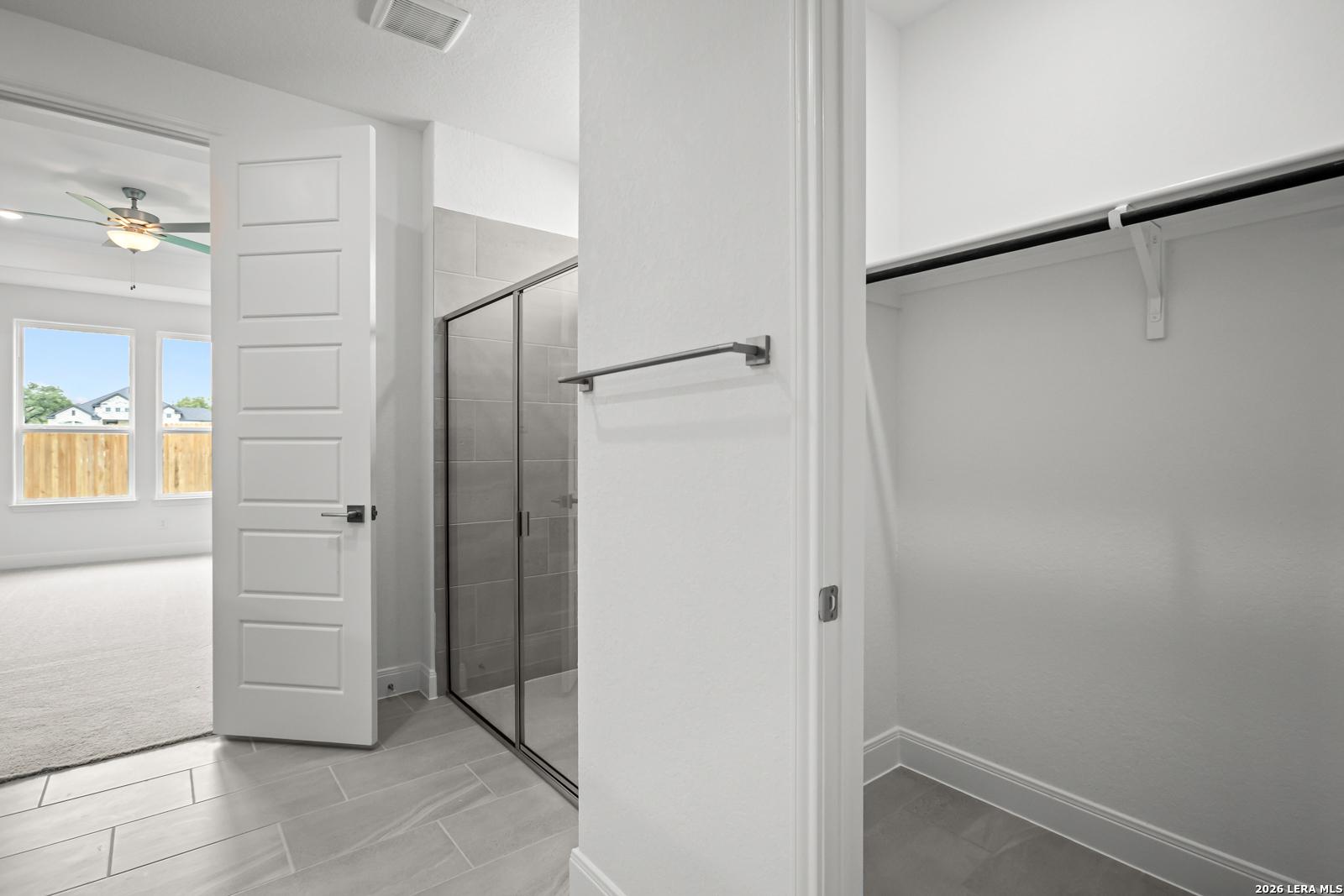 Walk-in closet and glass-enclosed shower in The Lanier G floor plan at The Reserve at Potranco Oaks, Castroville, Texas.