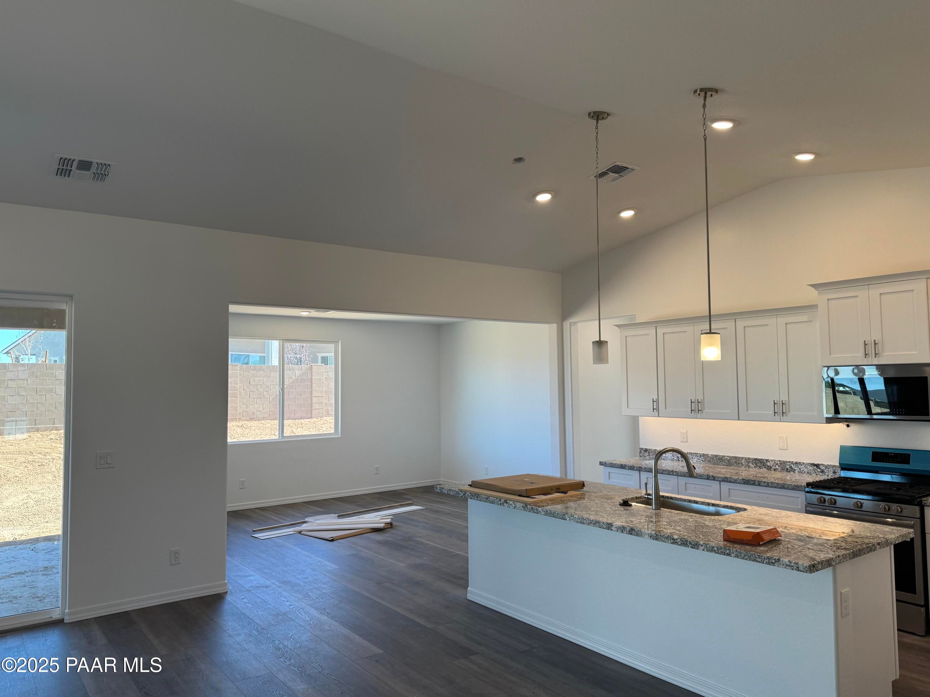 Modern open kitchen with white island, granite counters, stainless appliances in Davidson Homes Sunrise II A, Prescott AZ