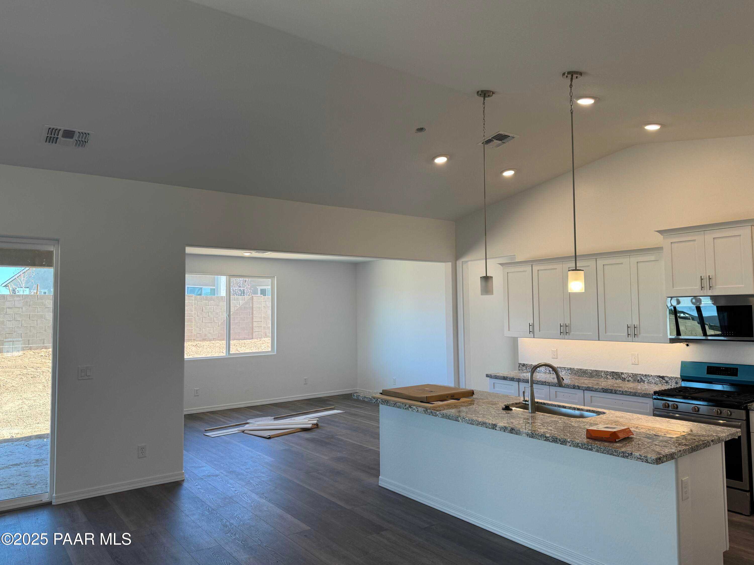 Modern open kitchen with white island, granite counters, stainless appliances in Davidson Homes Sunrise II A, Prescott AZ