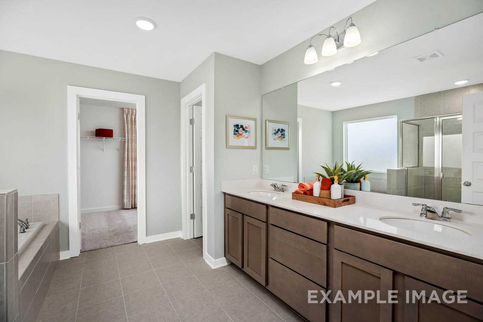 Spacious master bathroom in The Gordon B with double sink vanity, soaking tub, and walk-in shower