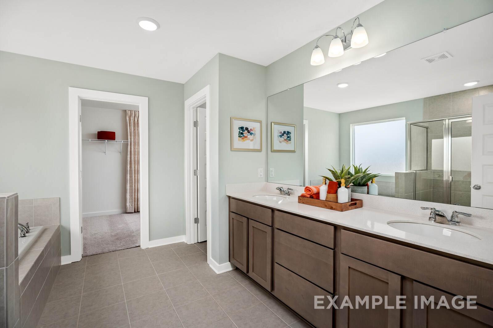Spacious master bathroom in The Gordon C featuring double vanity, soaking tub, and walk-in glass shower