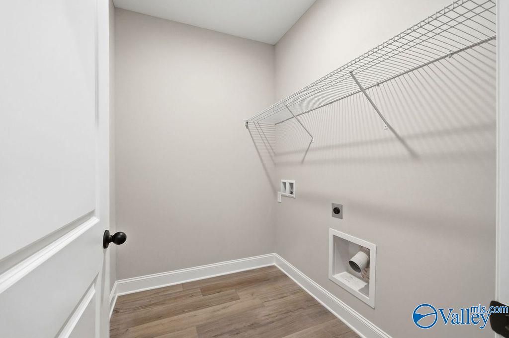 Laundry room with wire shelving and wood-look flooring in The Rockford floor plan by Davidson Homes in Cain Park, Hartselle.