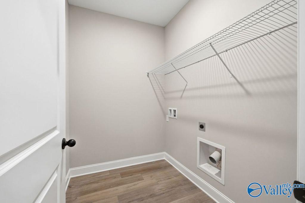 Laundry room with wire shelving and wood-look flooring in The Rockford floor plan by Davidson Homes in Cain Park, Hartselle.