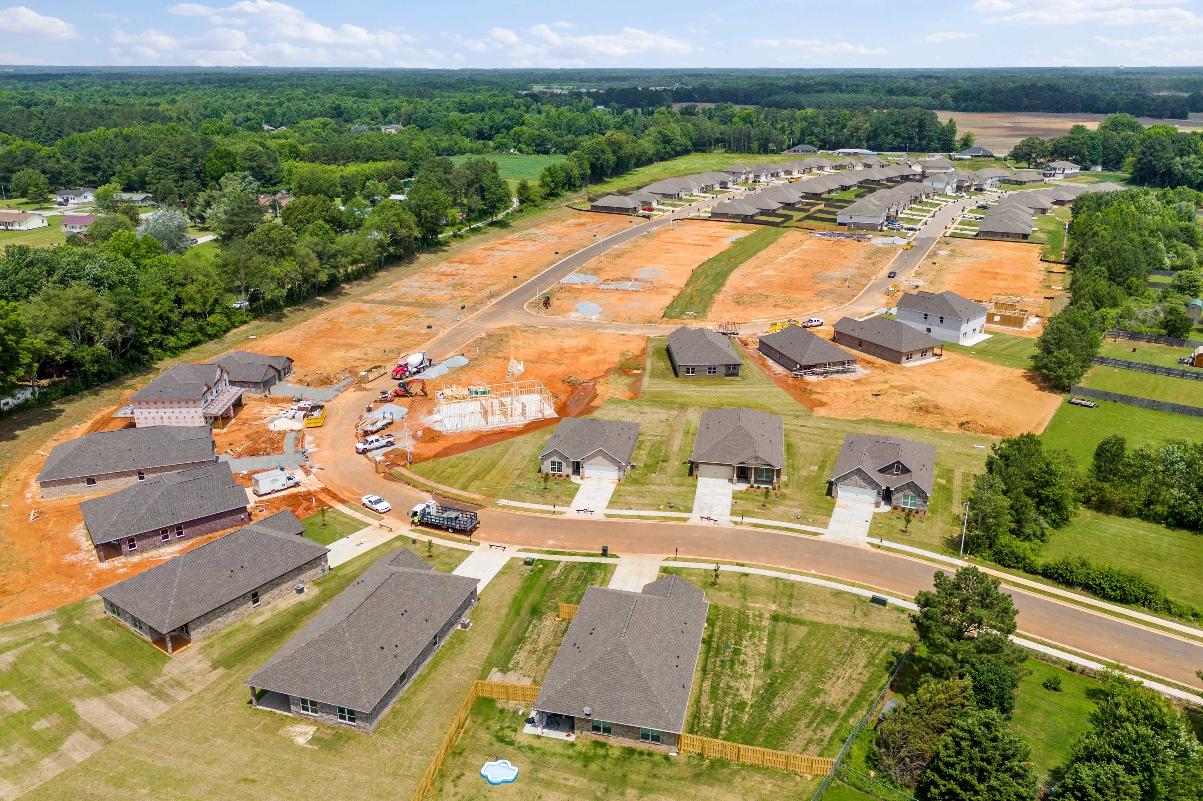 Aerial view of new homes under construction at Durham Farms in Harvest Alabama with red dirt lots and green landscapes