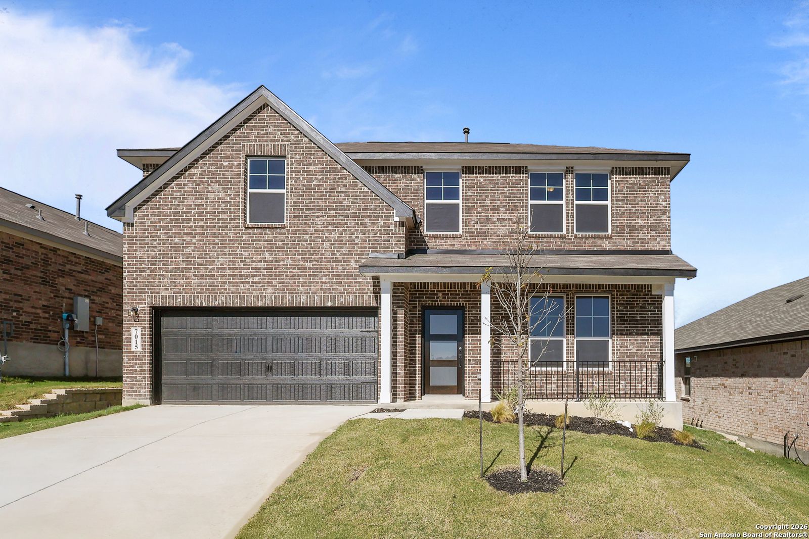 Two-story brick home with 2-car garage, covered porch, and manicured lawn in Comanche Ridge, San Antonio, Texas - Davidson Homes The Murray K