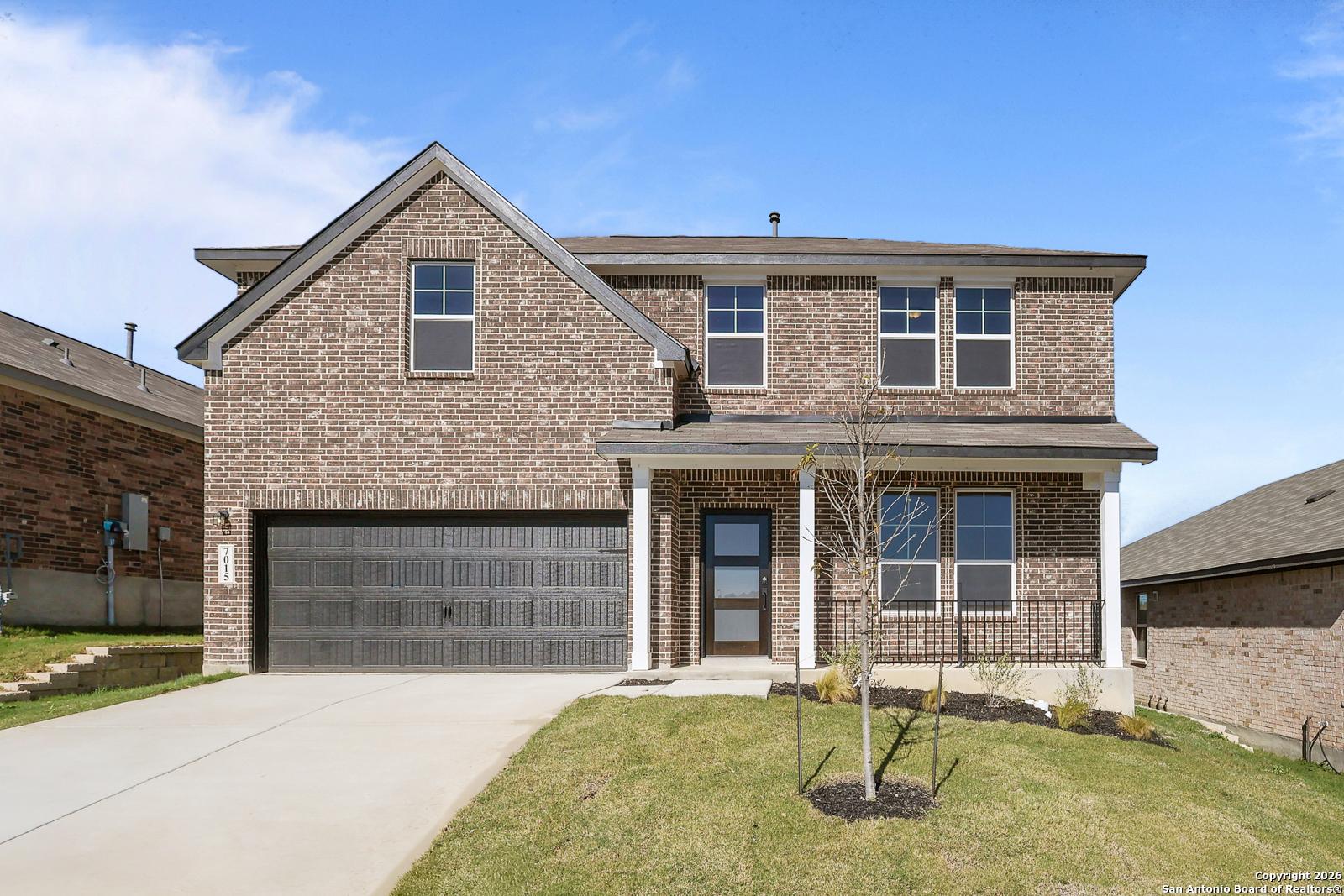 Two-story brick home with 2-car garage, covered porch, and manicured lawn in Comanche Ridge, San Antonio, Texas - Davidson Homes The Murray K