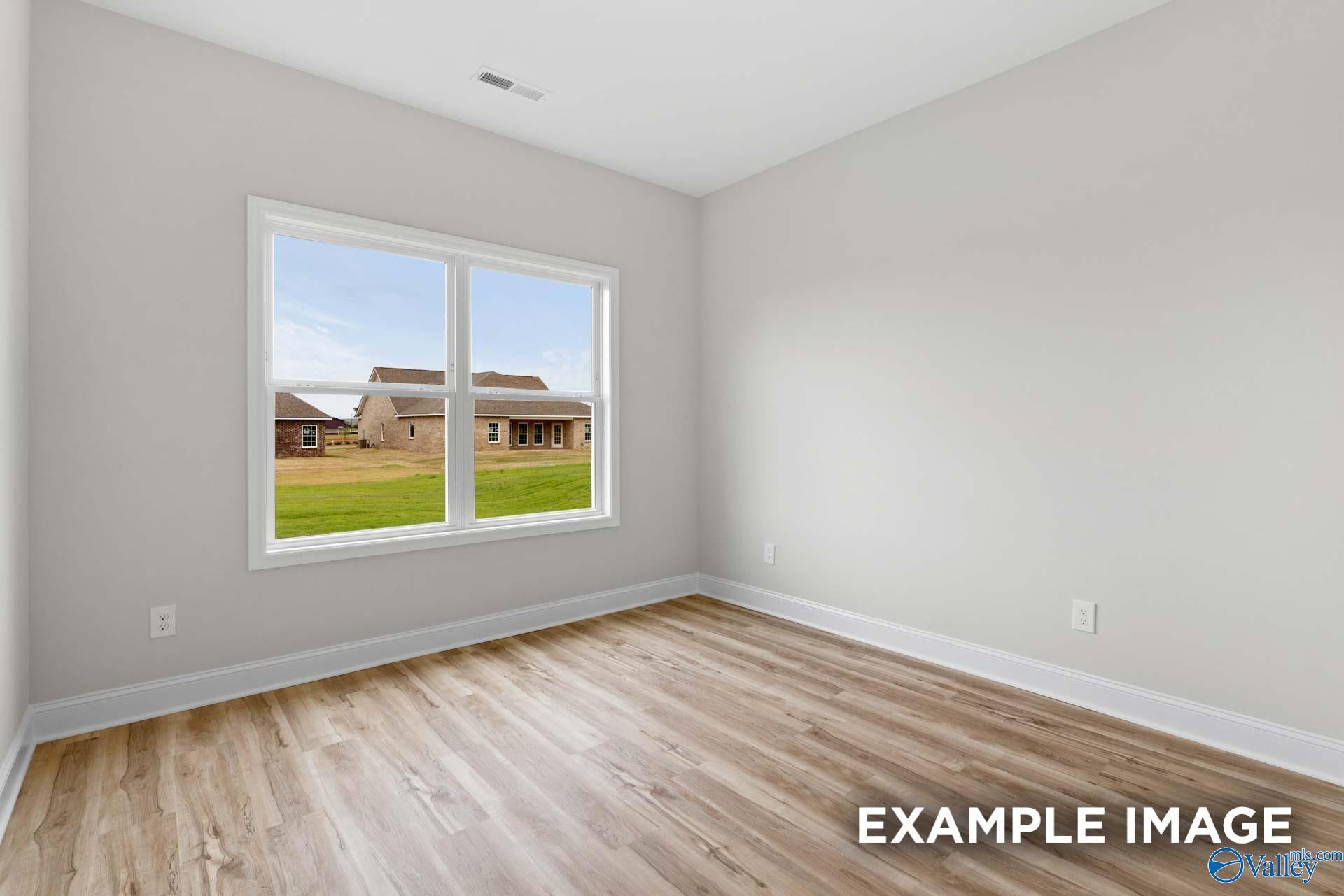 Bright bedroom with modern wood-style flooring in The Shelby B floor plan at Jaguar Hills, Huntsville, Alabama.