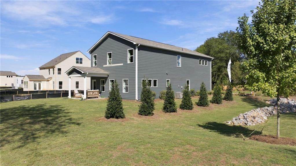 Rear exterior of 2-story Davidson Homes Sinclair B plan with covered patio and landscaped yard in Greene Farm, Cartersville, GA