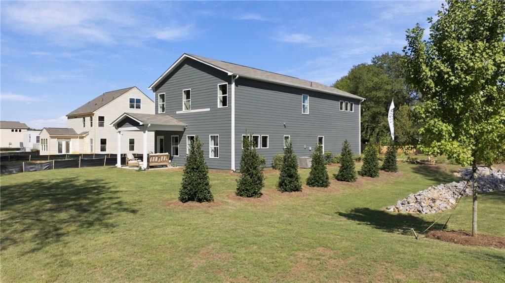 Rear exterior of 2-story Davidson Homes Sinclair B plan with covered patio and landscaped yard in Greene Farm, Cartersville, GA