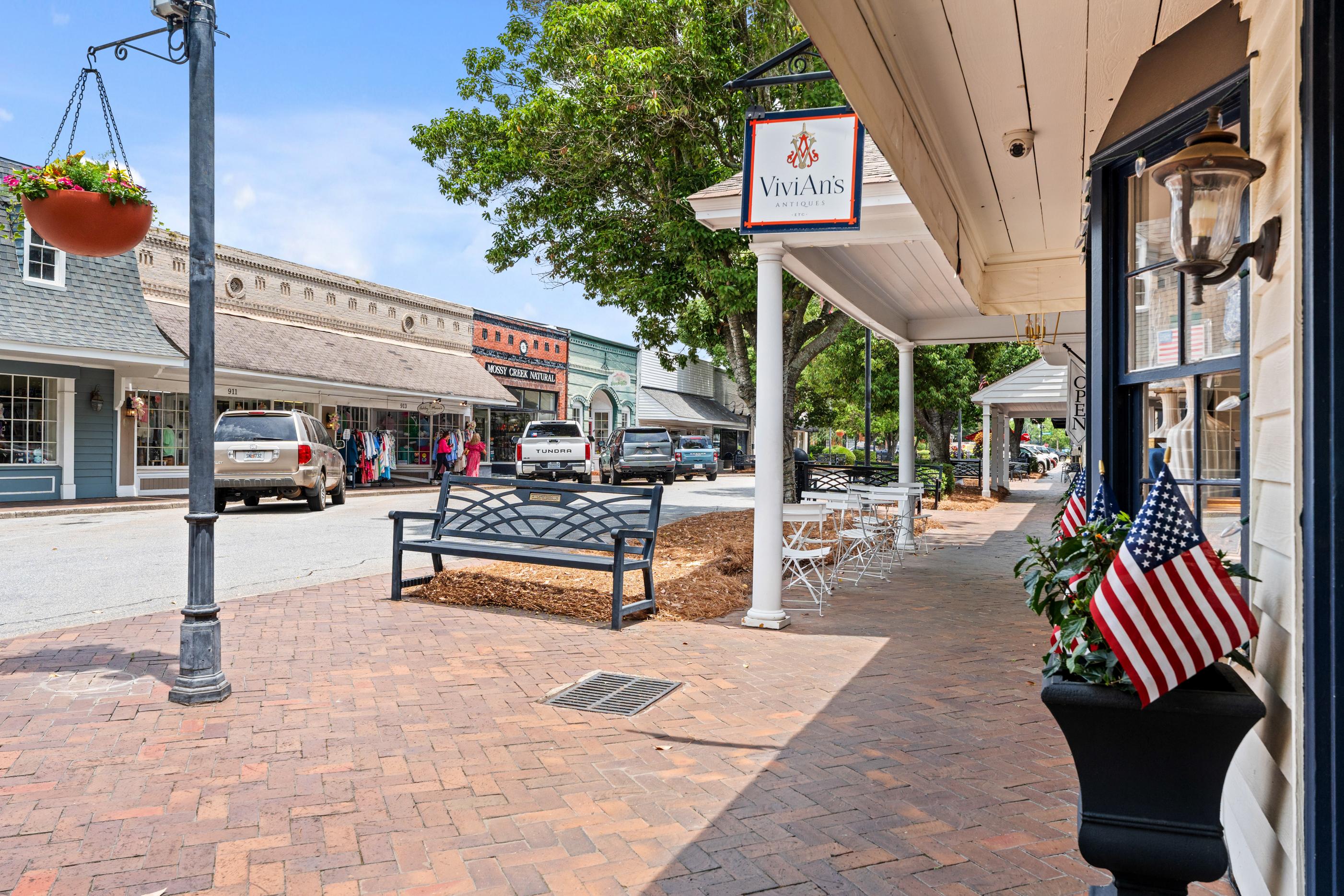 Historic downtown shopping area near Ivy Glen in Perry, Georgia featuring brick sidewalks, storefronts, and cafe seating.