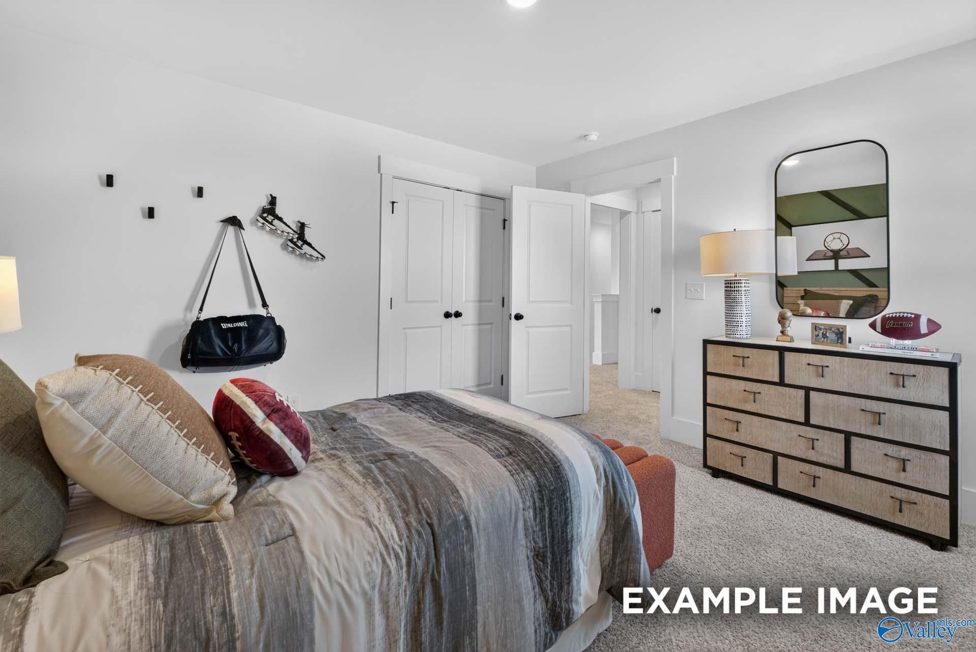 Sports-themed bedroom with striped bedding and wood dresser in Davidson Homes Ashport K plan, Forest Glen, Hazel Green, Alabama