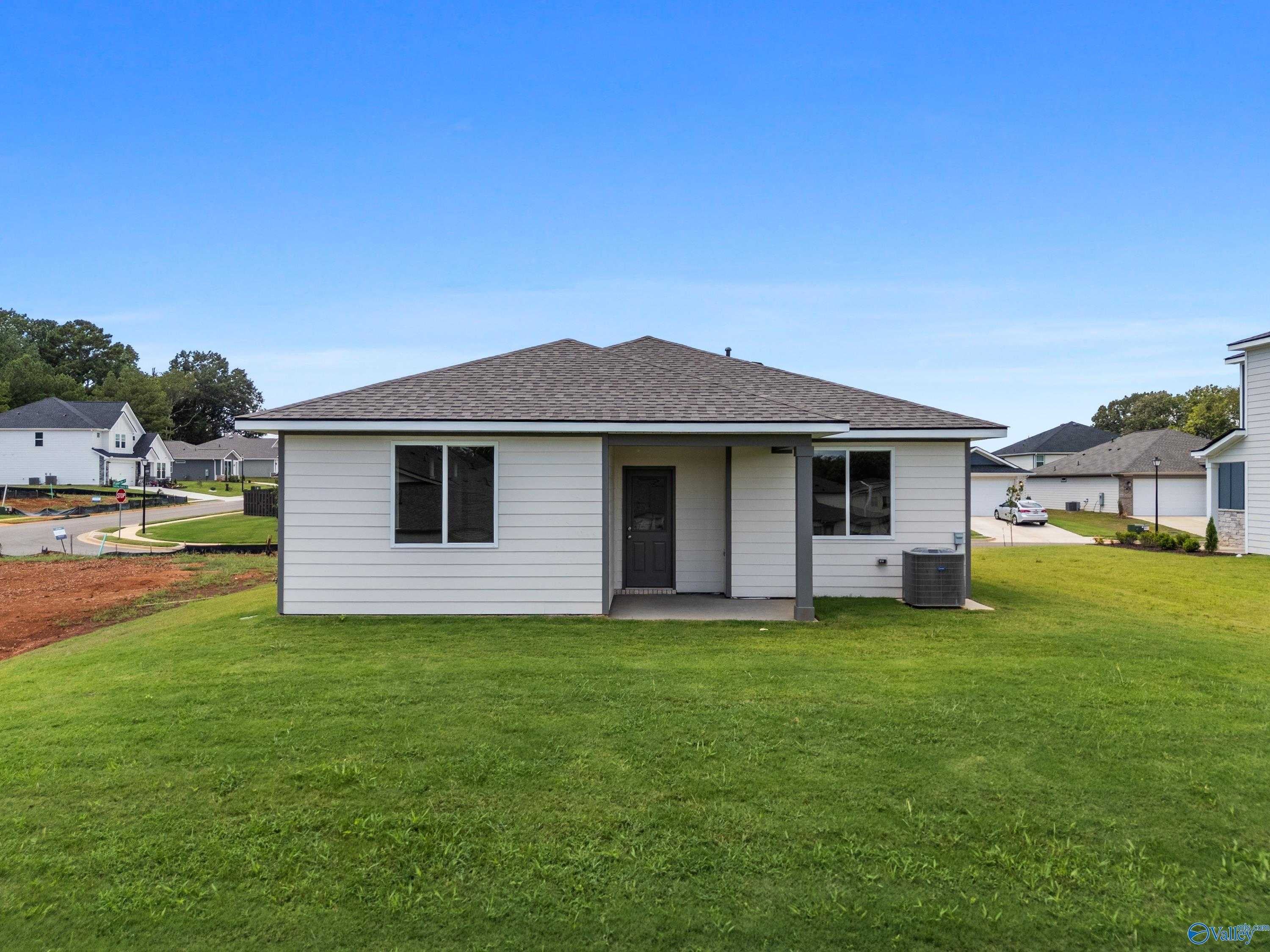 Rear view of The Malibu 2-bedroom single-story home with covered patio and green yard in Evergreen Mill, Madison, Alabama