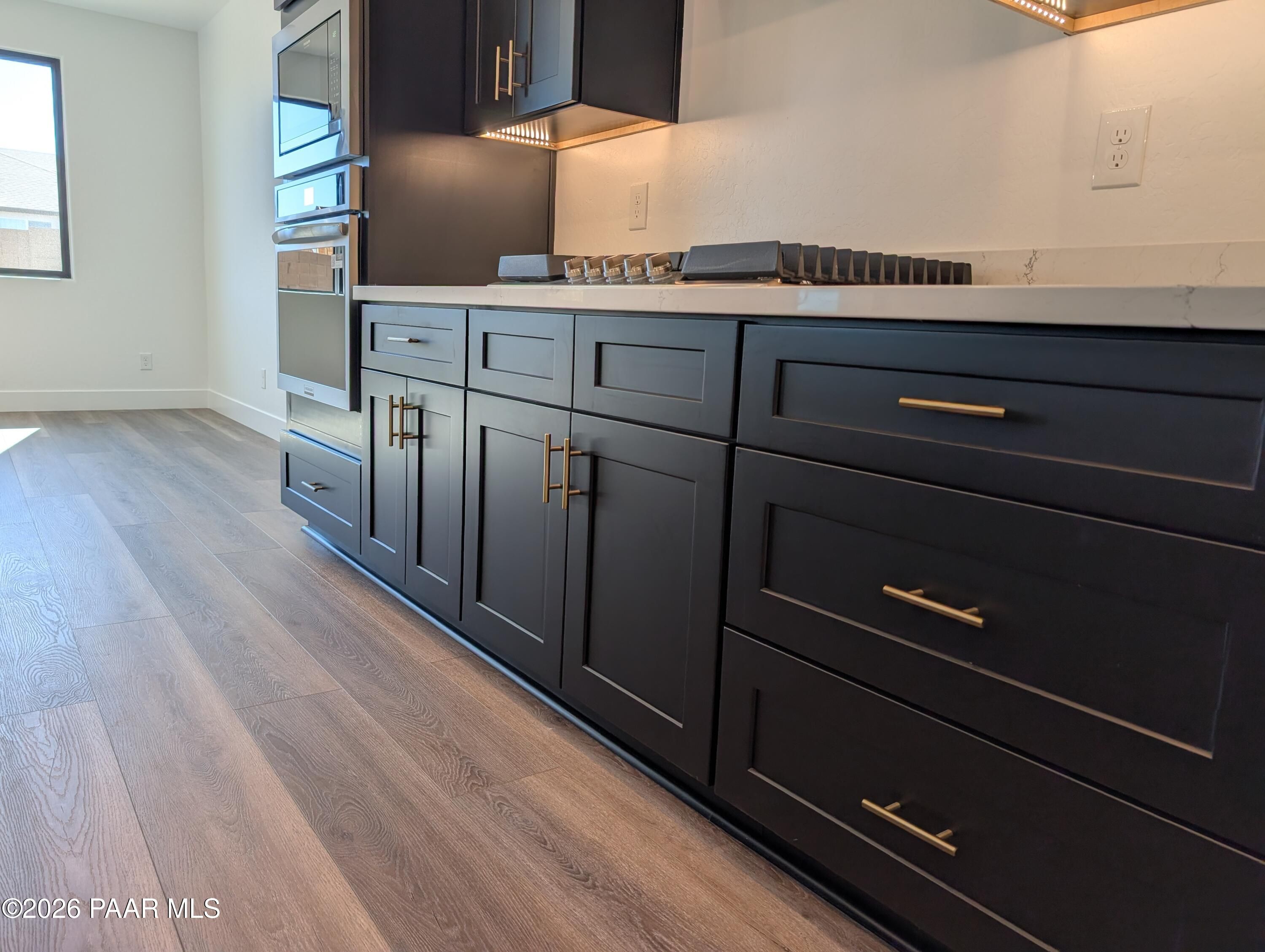 Modern kitchen featuring dark shaker cabinets, white quartz counters, stainless double oven in The Sheridan II G, Prescott AZ