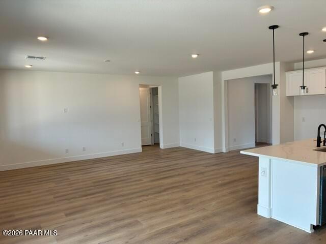 Open-concept living area with luxury vinyl plank flooring and white kitchen island in Davidson Homes Durango II G, Prescott AZ