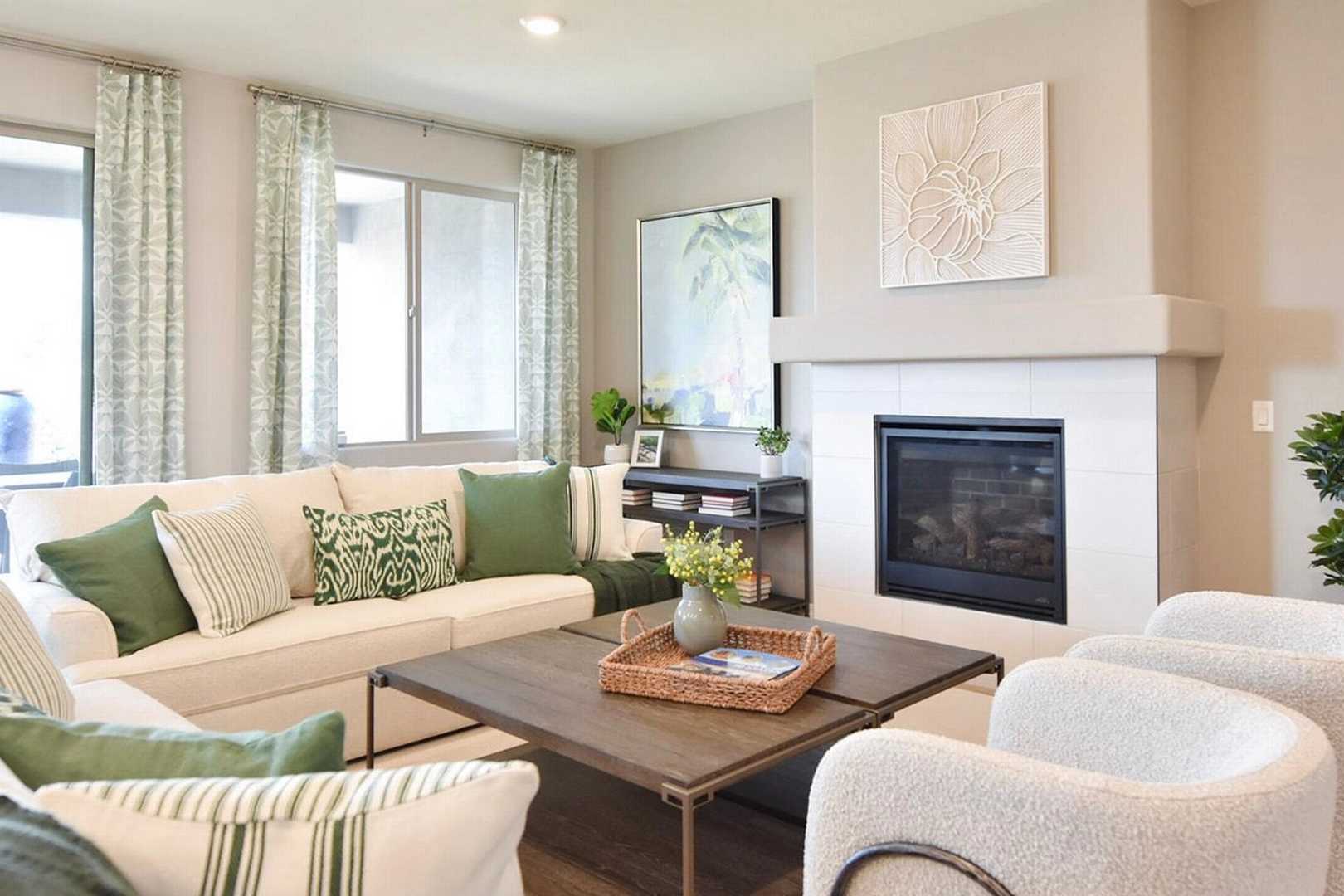 Spacious living room at North Ridge Pronghorn Ranch in Prescott Valley AZ with white sofa, green pillows, stone fireplace, abstract art and sliding doors
