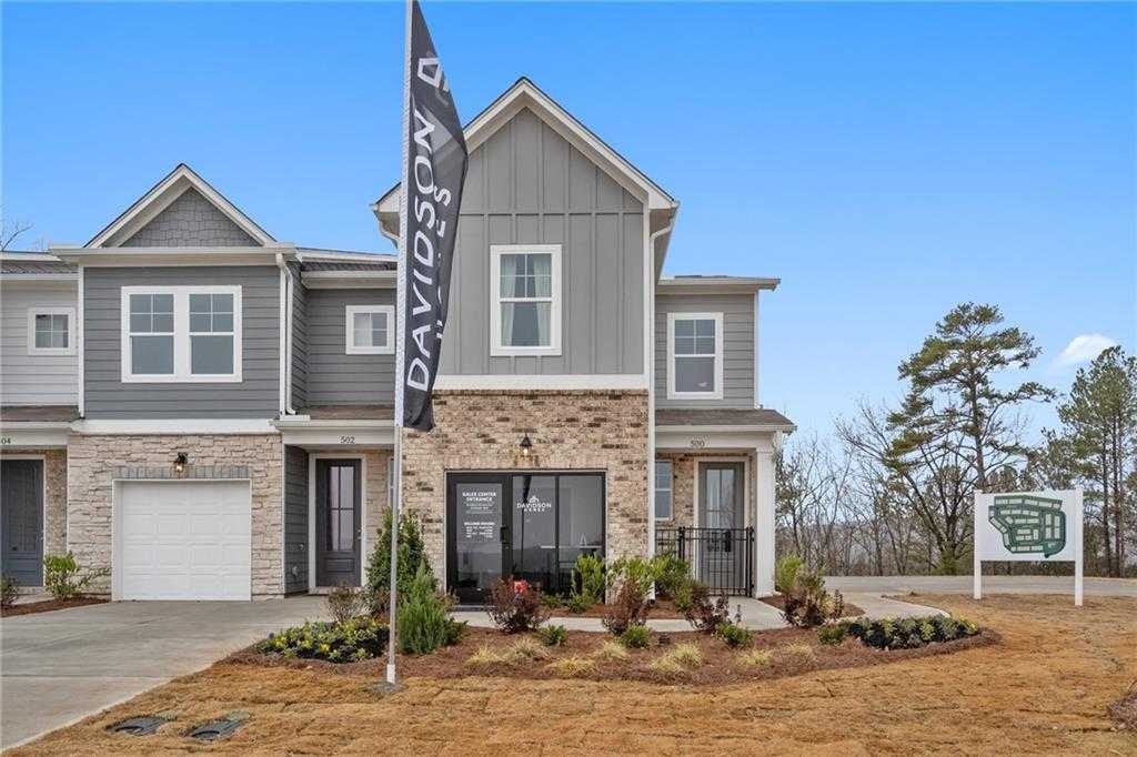 Modern 2-story gray Wilmington B home with brick accents, 1-car garage, and Davidson Homes flag in Stegall Village, Emerson, GA