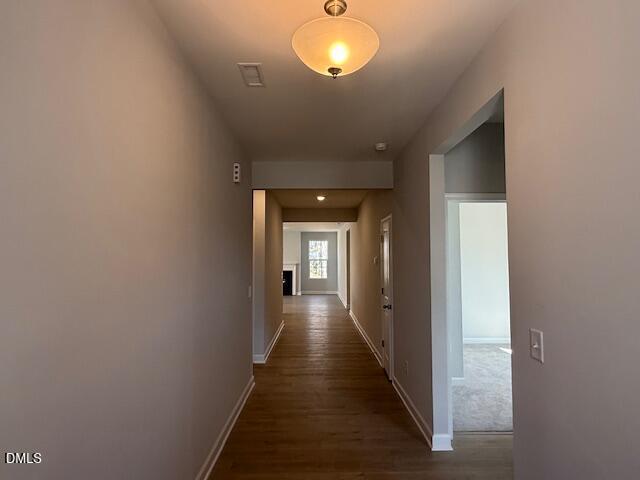 Long hallway with hardwood floors, neutral walls, and recessed lighting in The Daphne C 4-bedroom home, Woodland Crossing, Zebulon, NC