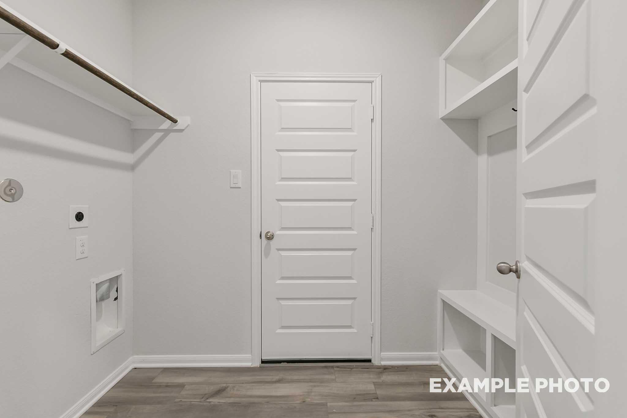 Functional utility room in The Frio floor plan featuring built-in storage shelving and washer dryer connections.