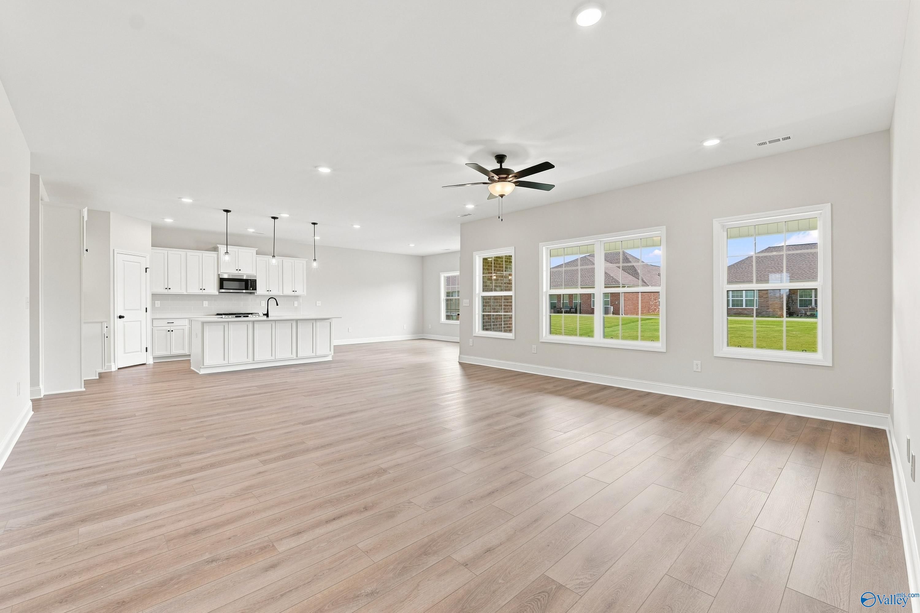Open-concept living room and white kitchen in The Rockford B floor plan at Kendall Downs, Toney, Alabama.