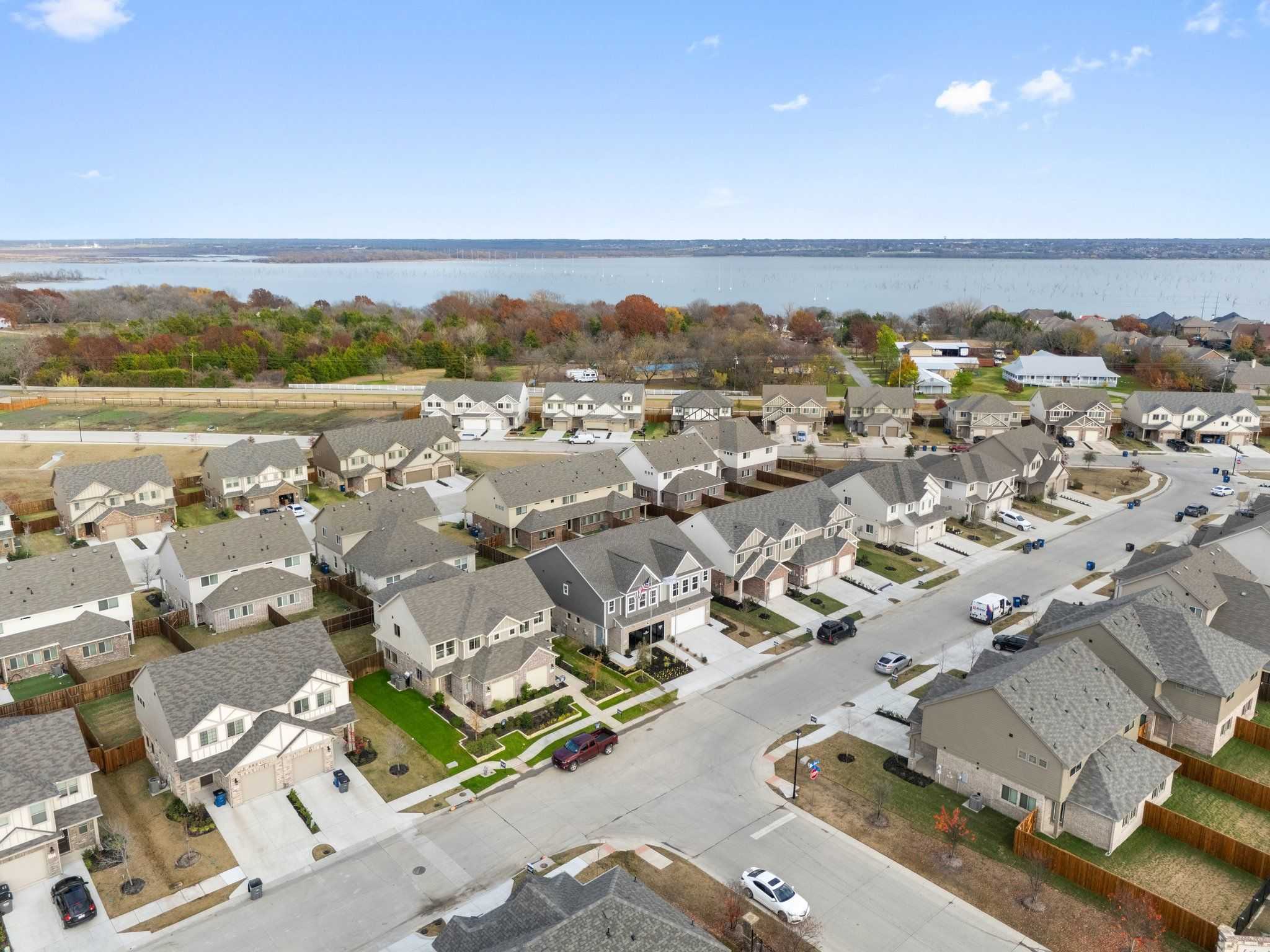 Aerial view of Lake Park Villas neighborhood in Wylie, Texas, with Davidson Homes two-story houses, streets, and scenic lake backdrop