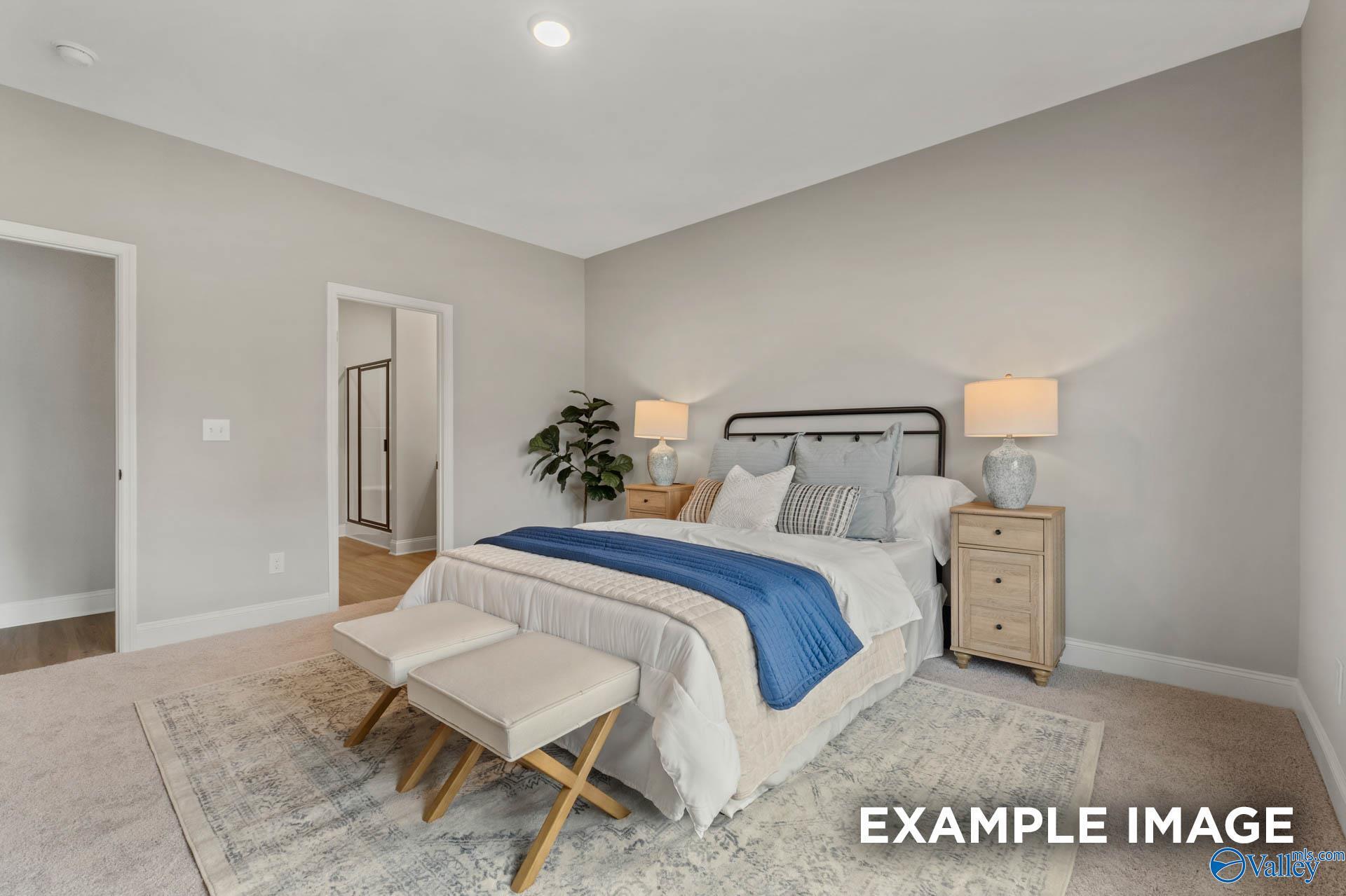 Cozy bedroom with neutral decor and en-suite bathroom in The Daphne C floor plan at Walker's Hill, Meridianville, Alabama.