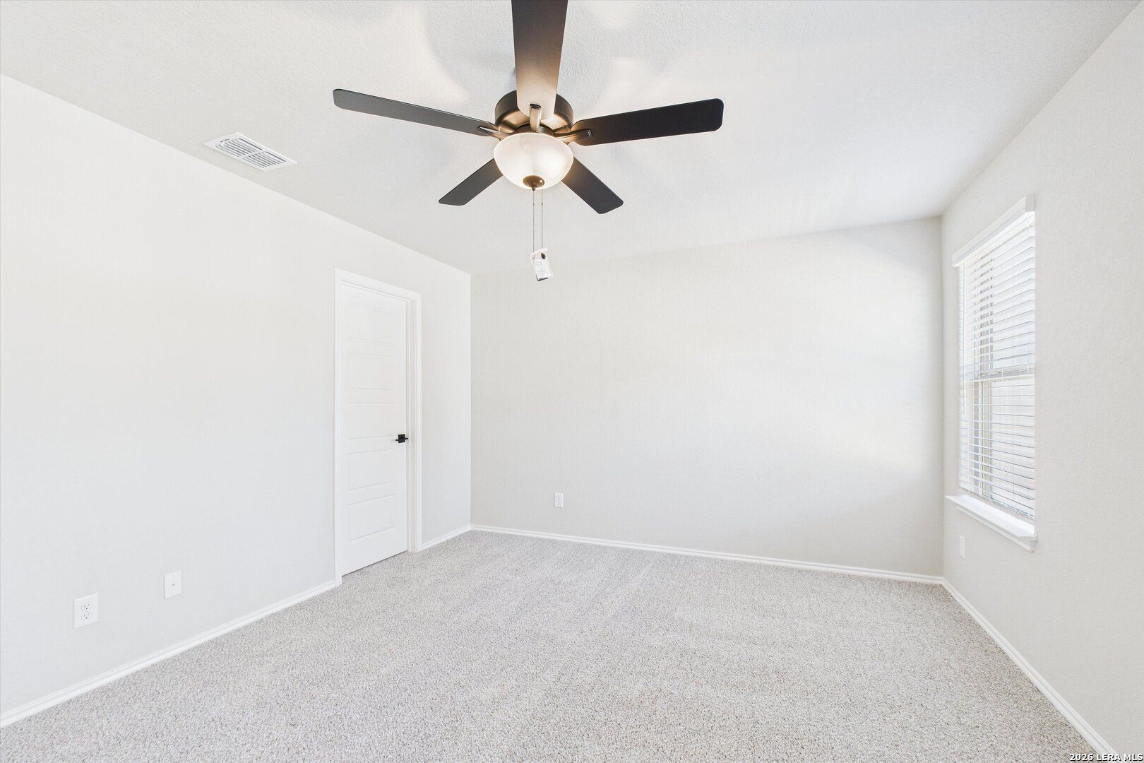 Bright empty bedroom with ceiling fan, carpet floor, and window blinds in Davidson Homes The Charlotte A, San Antonio