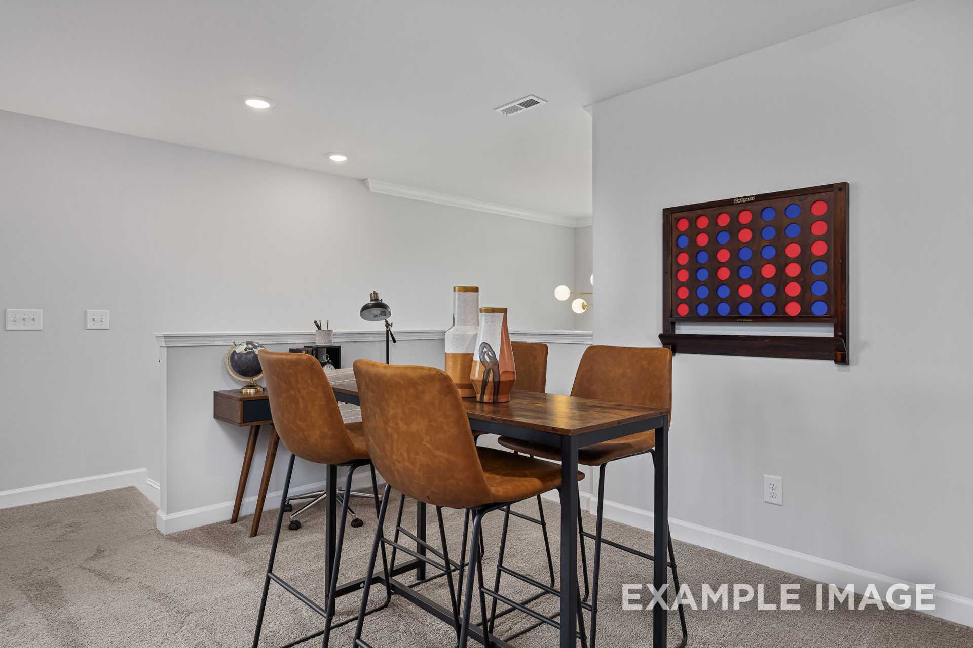 Upper floor loft in The Adalynn A featuring wooden desk, leather chairs, and red-blue Connect Four game wall