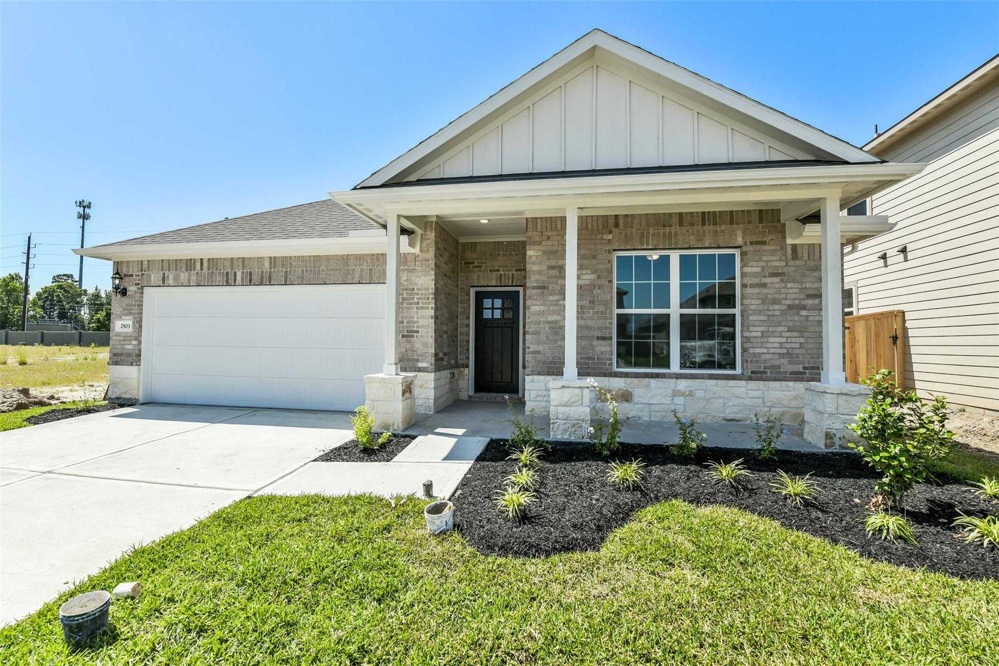 Modern 4-bedroom single-story home with brick facade, 2-car garage, covered porch, and landscaped yard in Sundance Cove, Crosby, TX