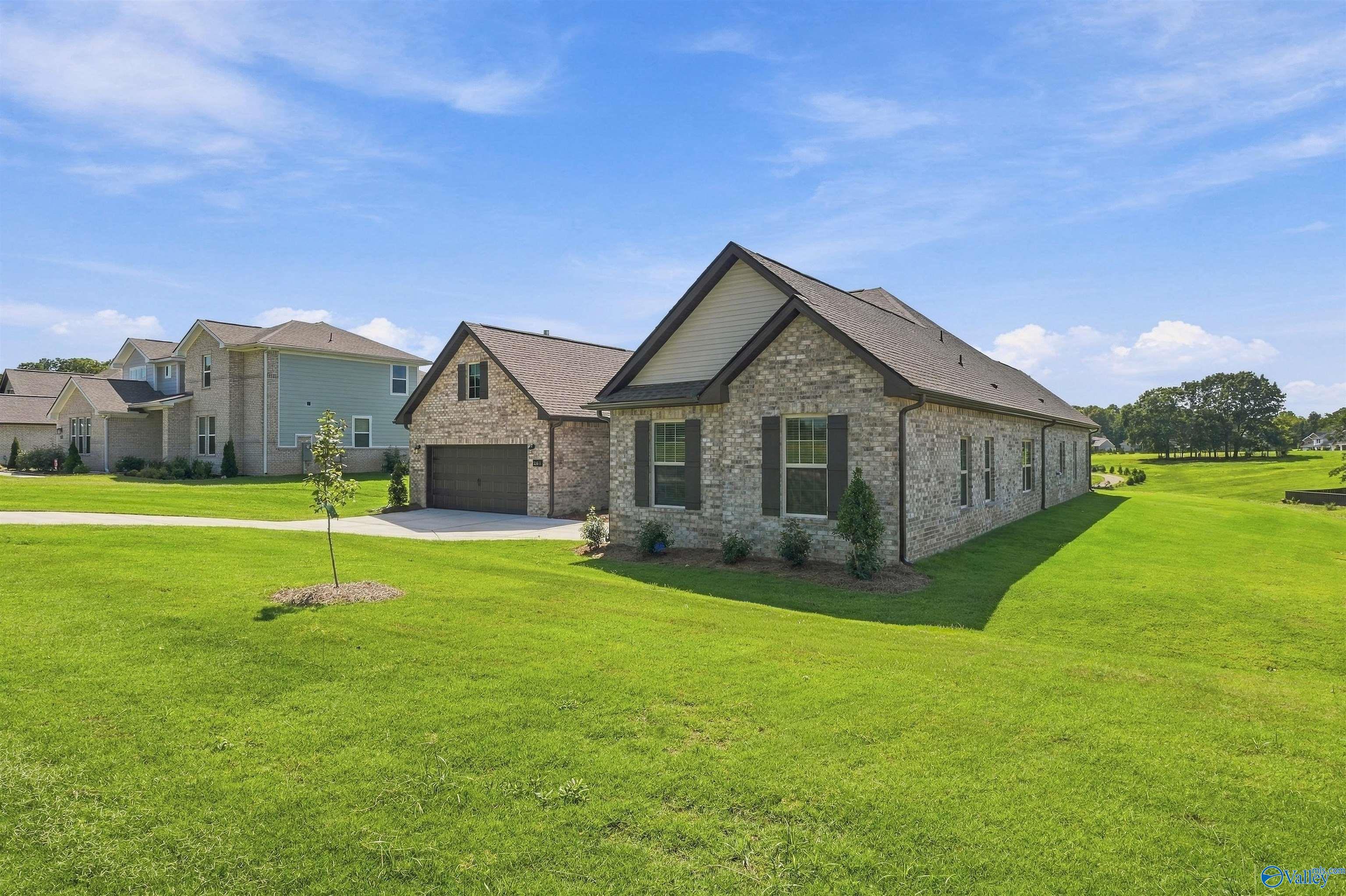 Single-story brick home with side-entry garage and lush green lawn in Davidson Homes' Riverton Preserve, Huntsville, Alabama