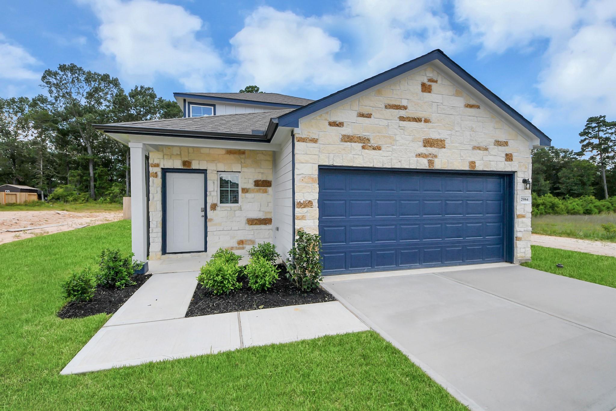 Two-story Davidson Homes Sabine E floor plan with stone facade and two-car garage in Liberty Estates, Cleveland, Texas.