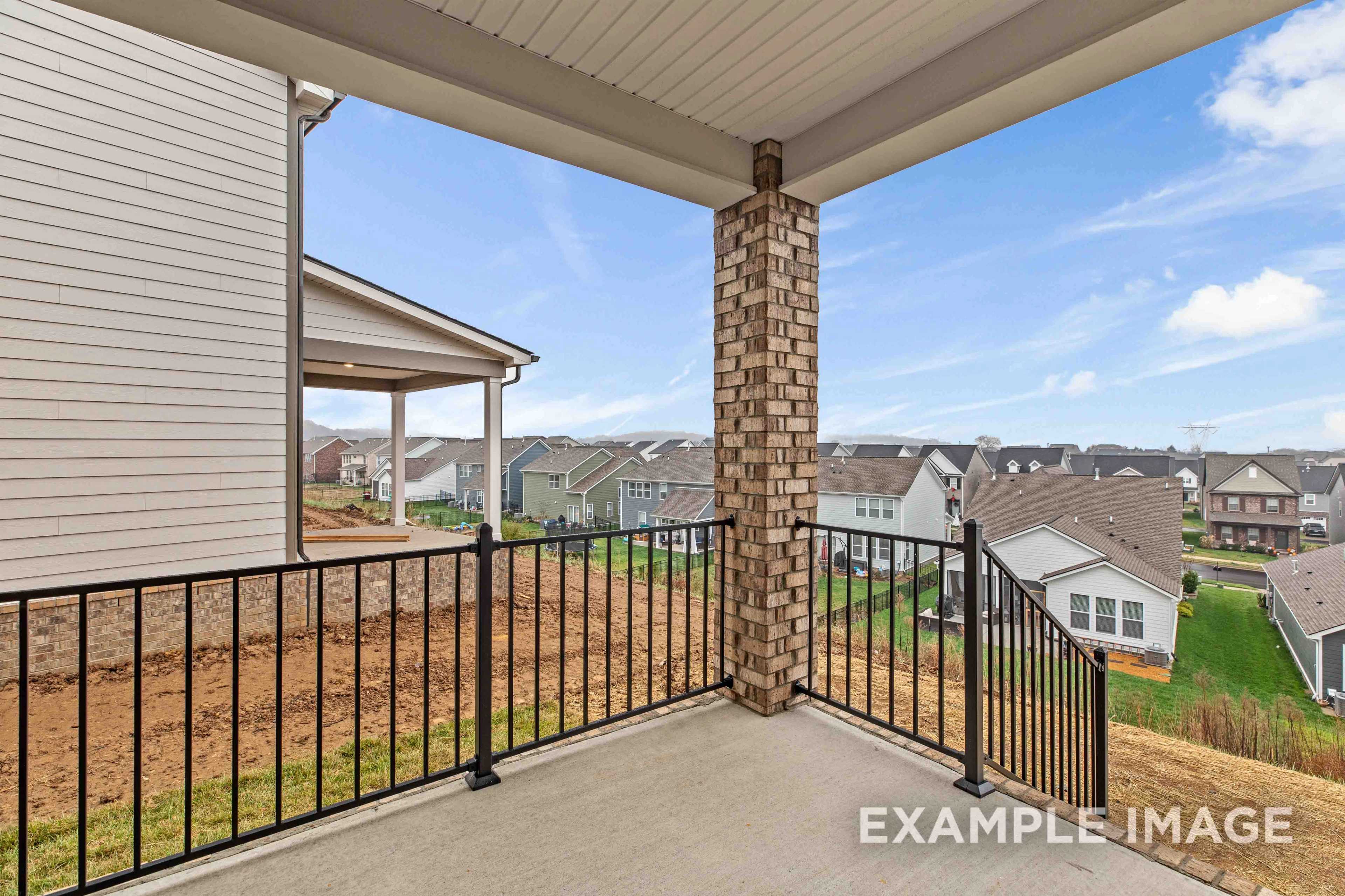 Spacious upper balcony of The Charleston home with black metal railing, brick column, overlooking Mt. Juliet neighborhood