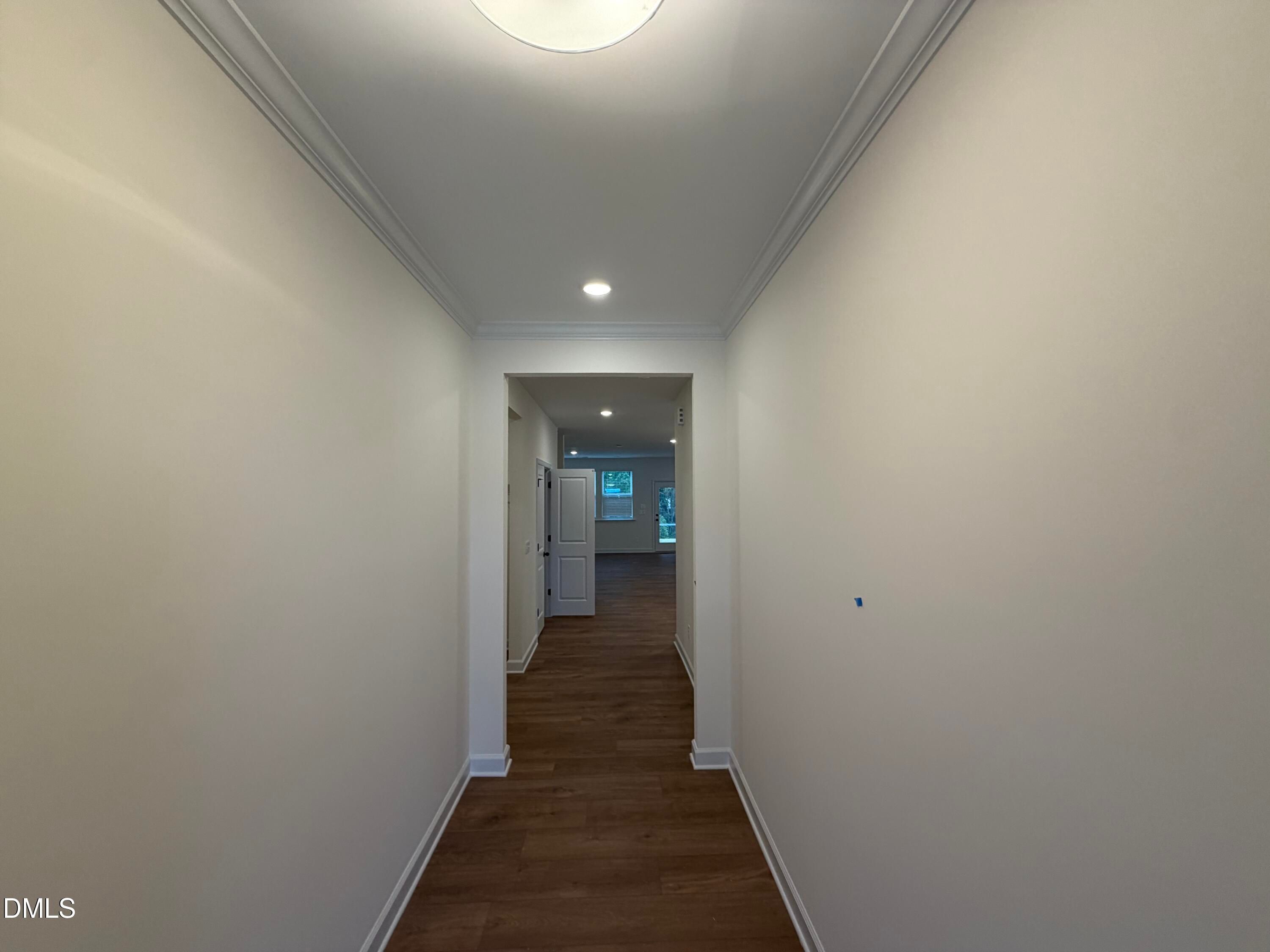 Bright hallway with crown molding and hardwood floors leading to open living area in Davidson Homes The Ashport M, Wendell Ridge, NC