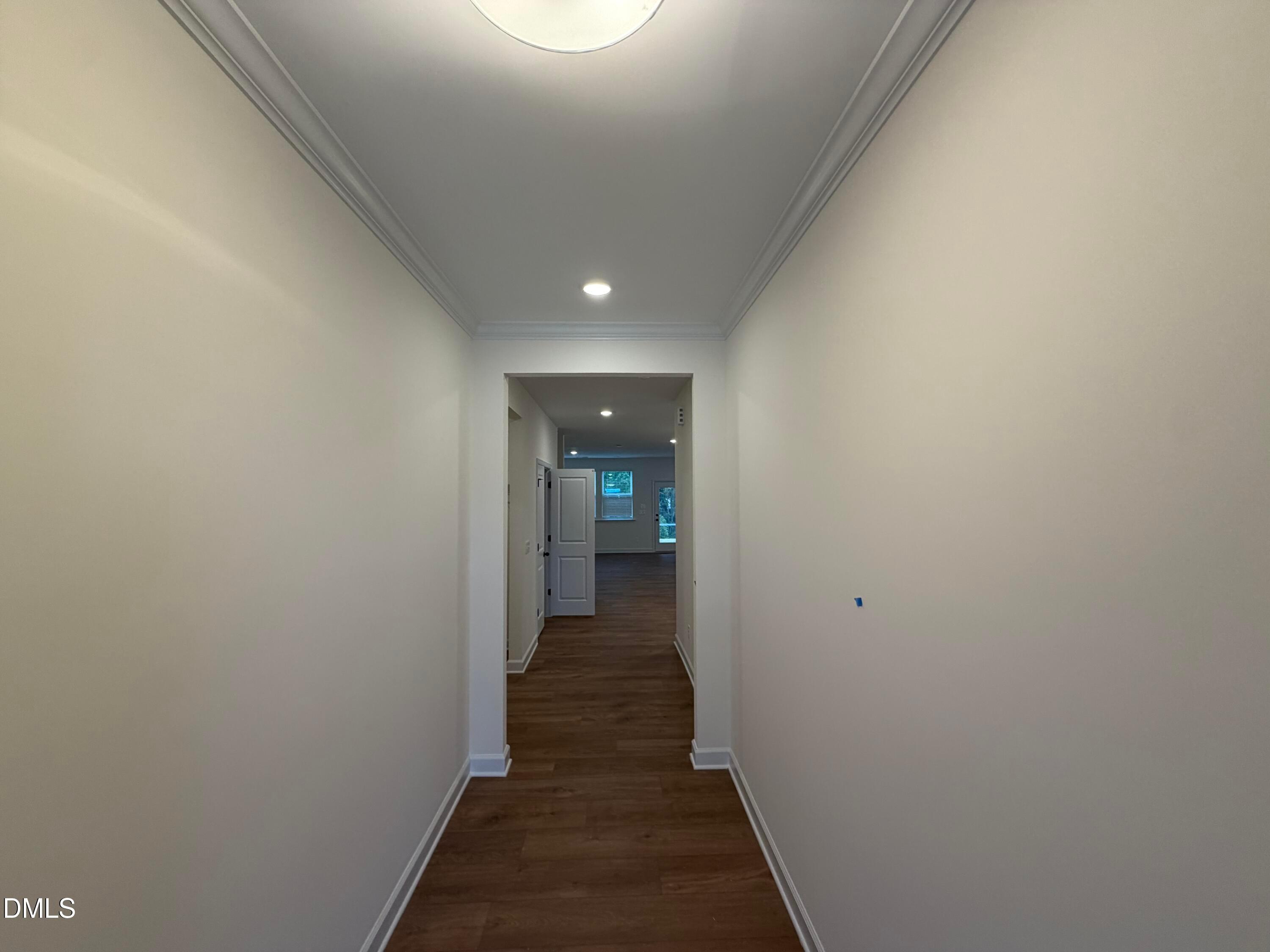 Bright hallway with crown molding and hardwood floors leading to open living area in Davidson Homes The Ashport M, Wendell Ridge, NC