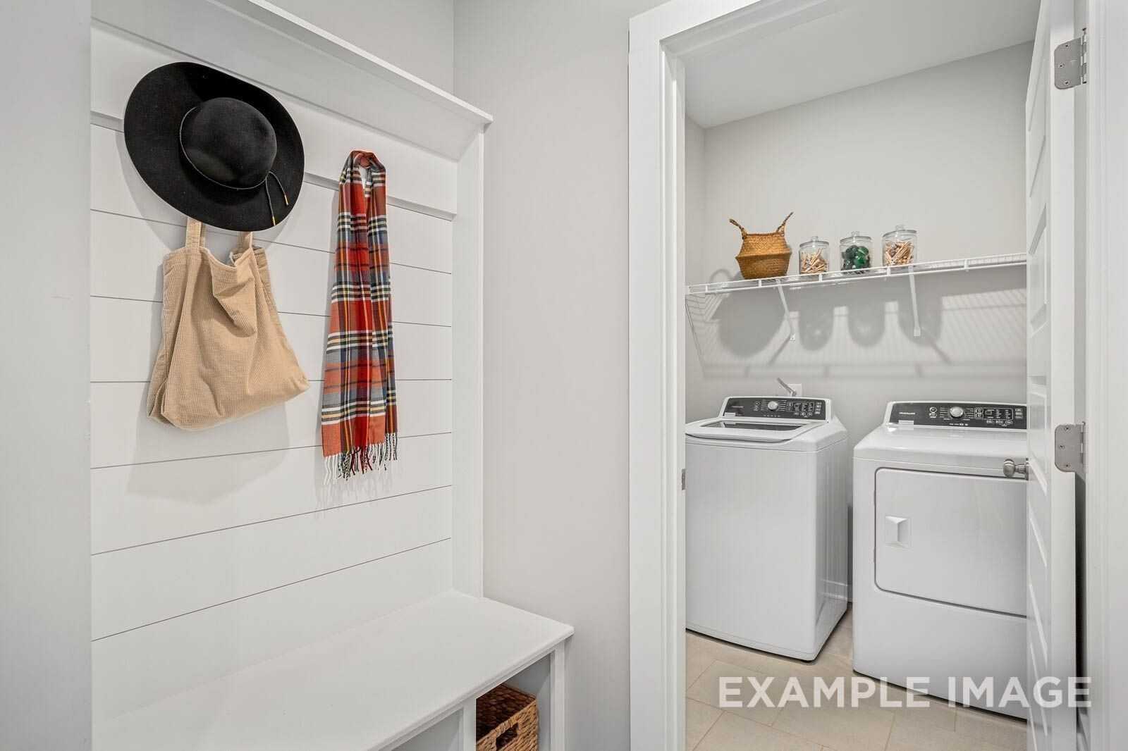 Mudroom with coat rack, plaid scarf, hat, bag, bench, and adjacent laundry featuring washer dryer in Davidson Homes The Franklin B, White House TN