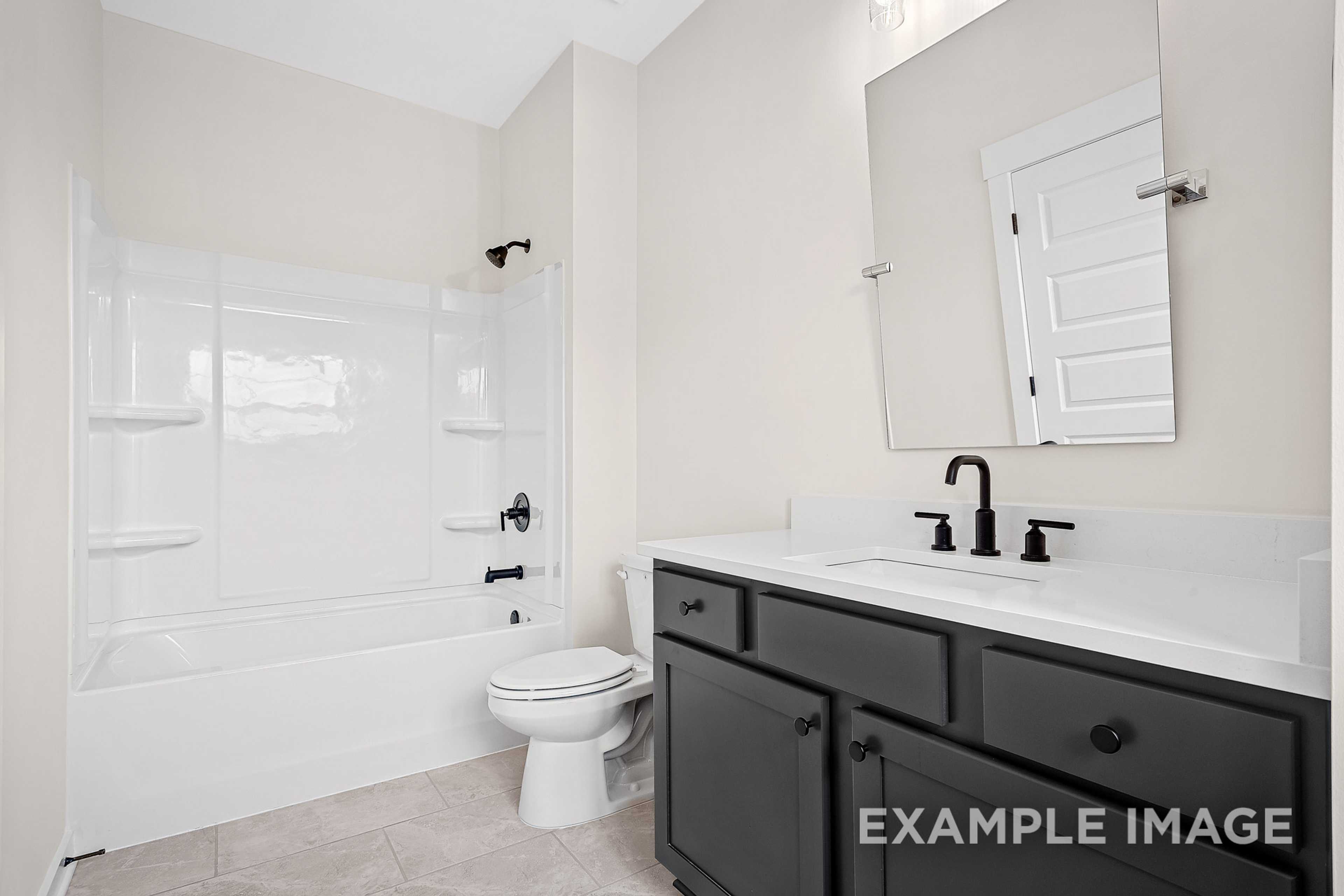 Master bathroom in The Hawkins: white tub-shower combo, black vanity with single sink, modern black fixtures, light walls