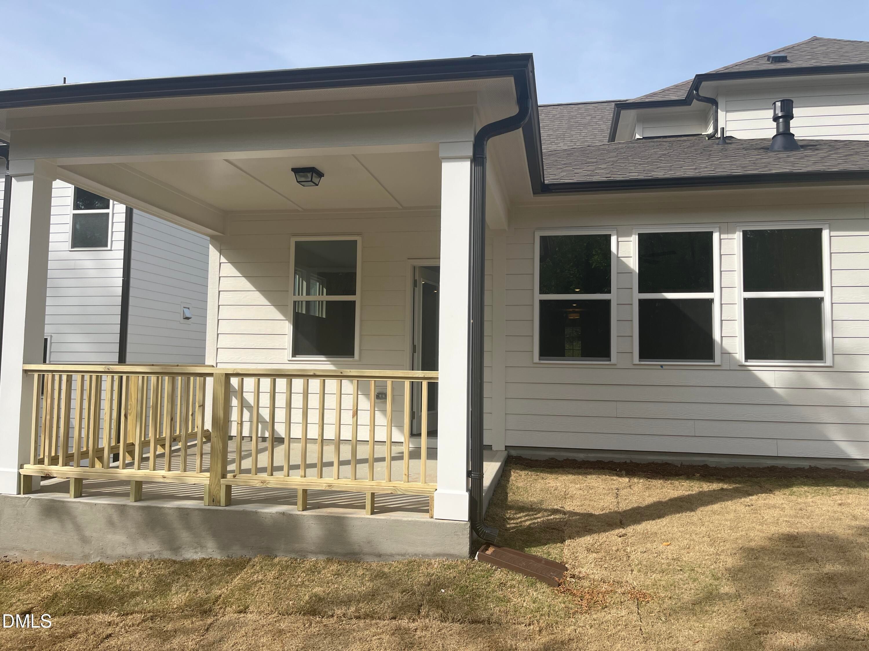 Covered back porch with wooden railing and large windows in Davidson Homes The Ashport L, Wake Forest, NC