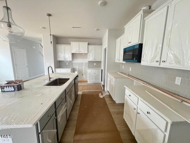 Modern white shaker kitchen with large quartz island, sink, and pendant lights in Davidson Homes Adalynn B, Lillington, NC