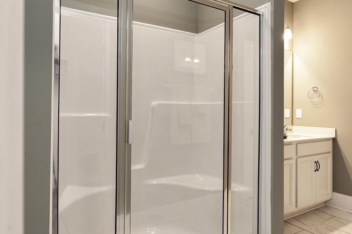 Spacious glass-enclosed walk-in shower in modern bathroom at Williams Pointe, Huntsville AL with white subway tile and vanity