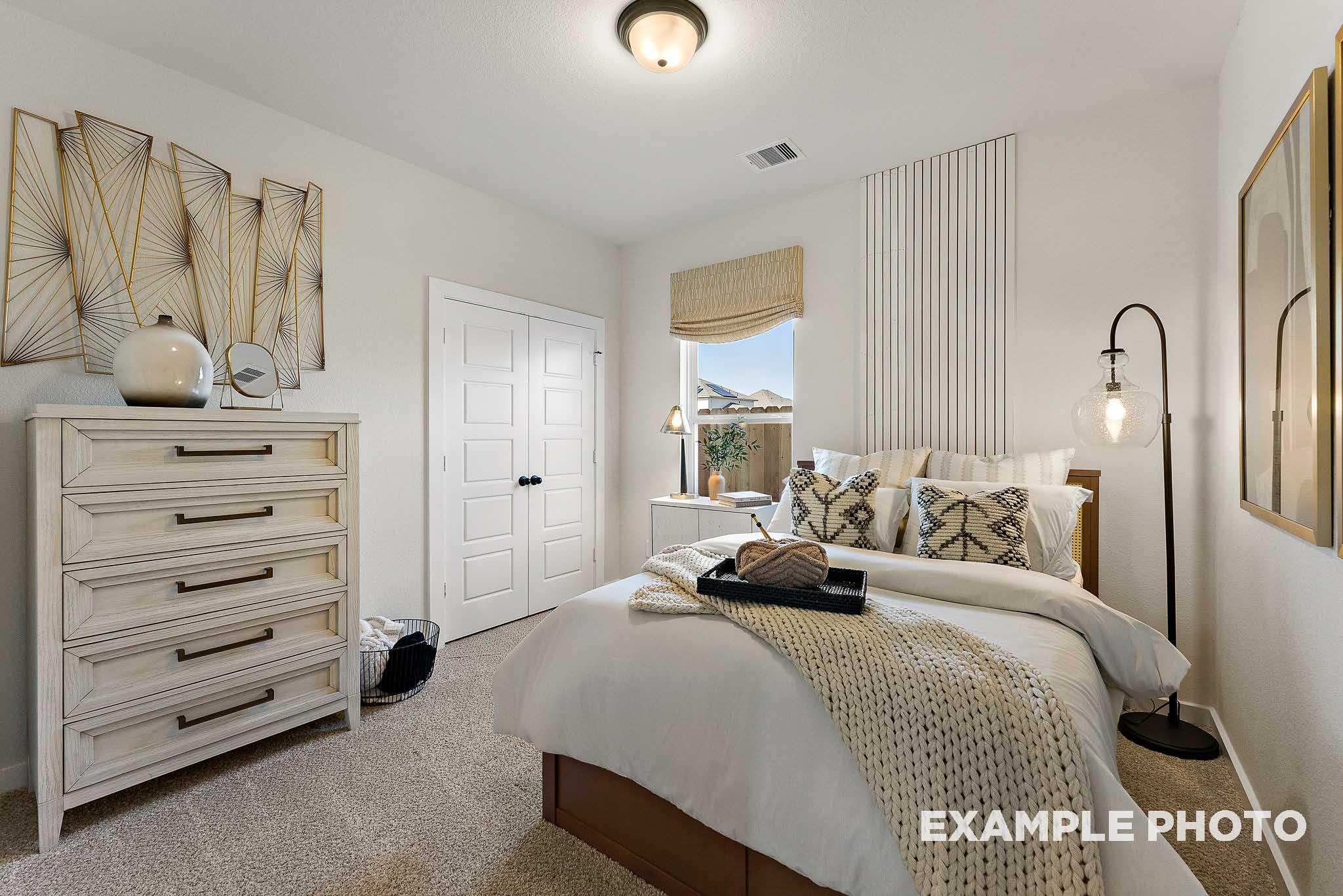 Cozy secondary bedroom with modern decor in The Everett E floor plan by Davidson Homes in Sundance Cove, Crosby, Texas.