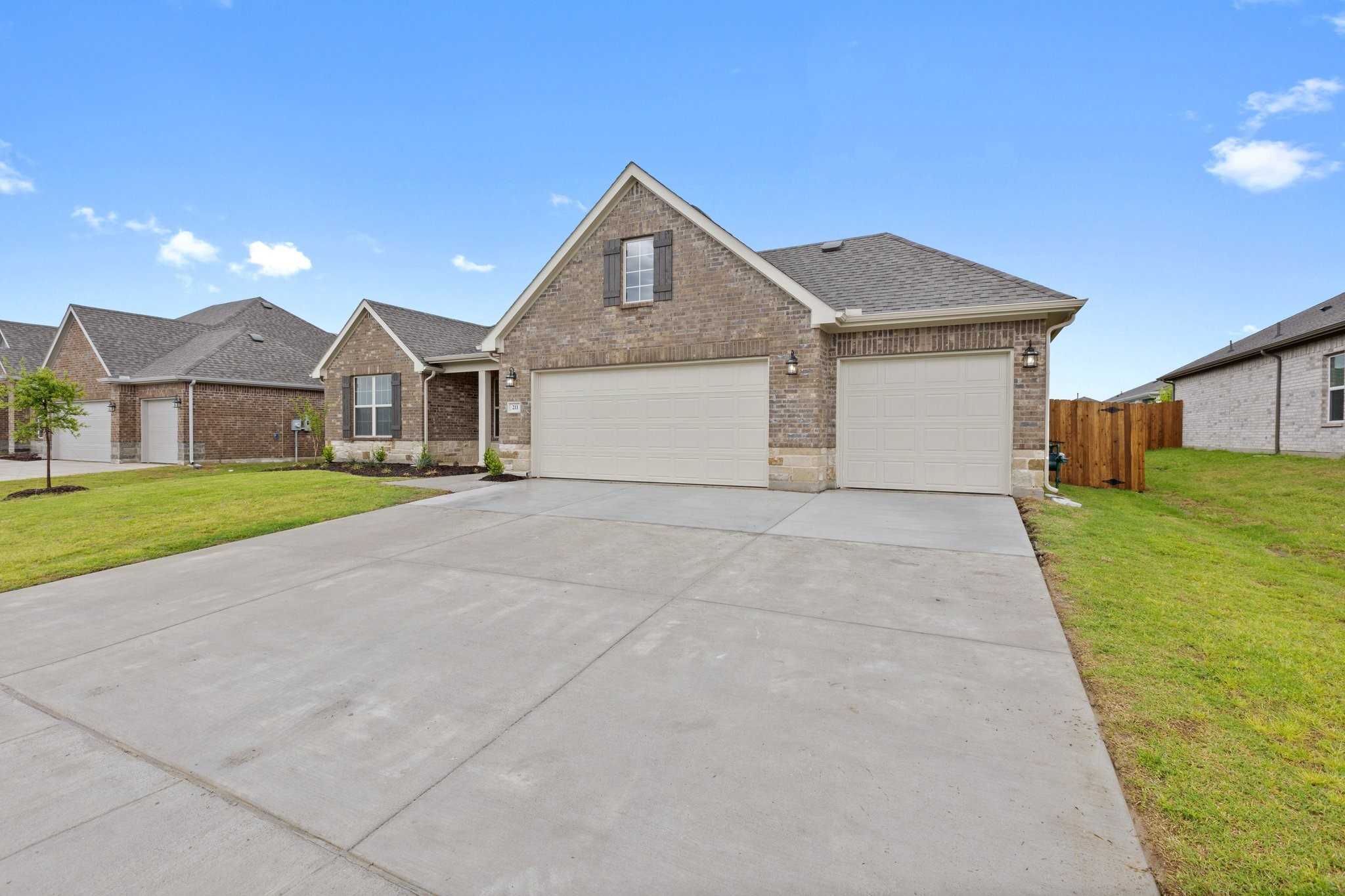 Brick single-story home with 3-car garage, wide driveway, and green lawn in Waverly Estates, Josephine, Texas - Davidson Homes Rockford C