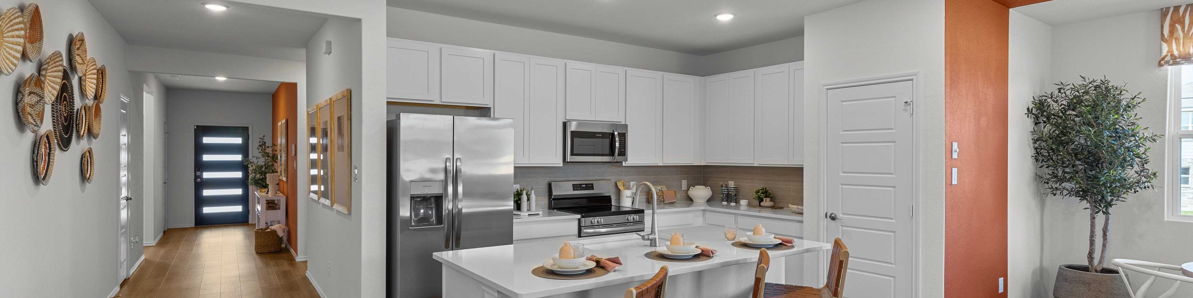 Modern open kitchen in new Converse home with white cabinets, stainless steel appliances, and wood island bar