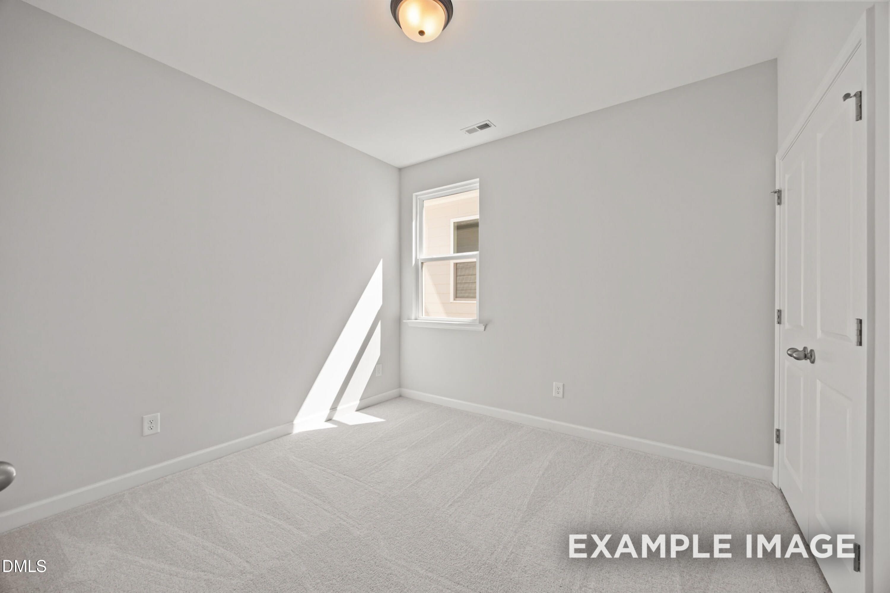 Bright, carpeted bedroom with white walls and natural light in The Alexander B floor plan, Forestville Yard, Knightdale.
