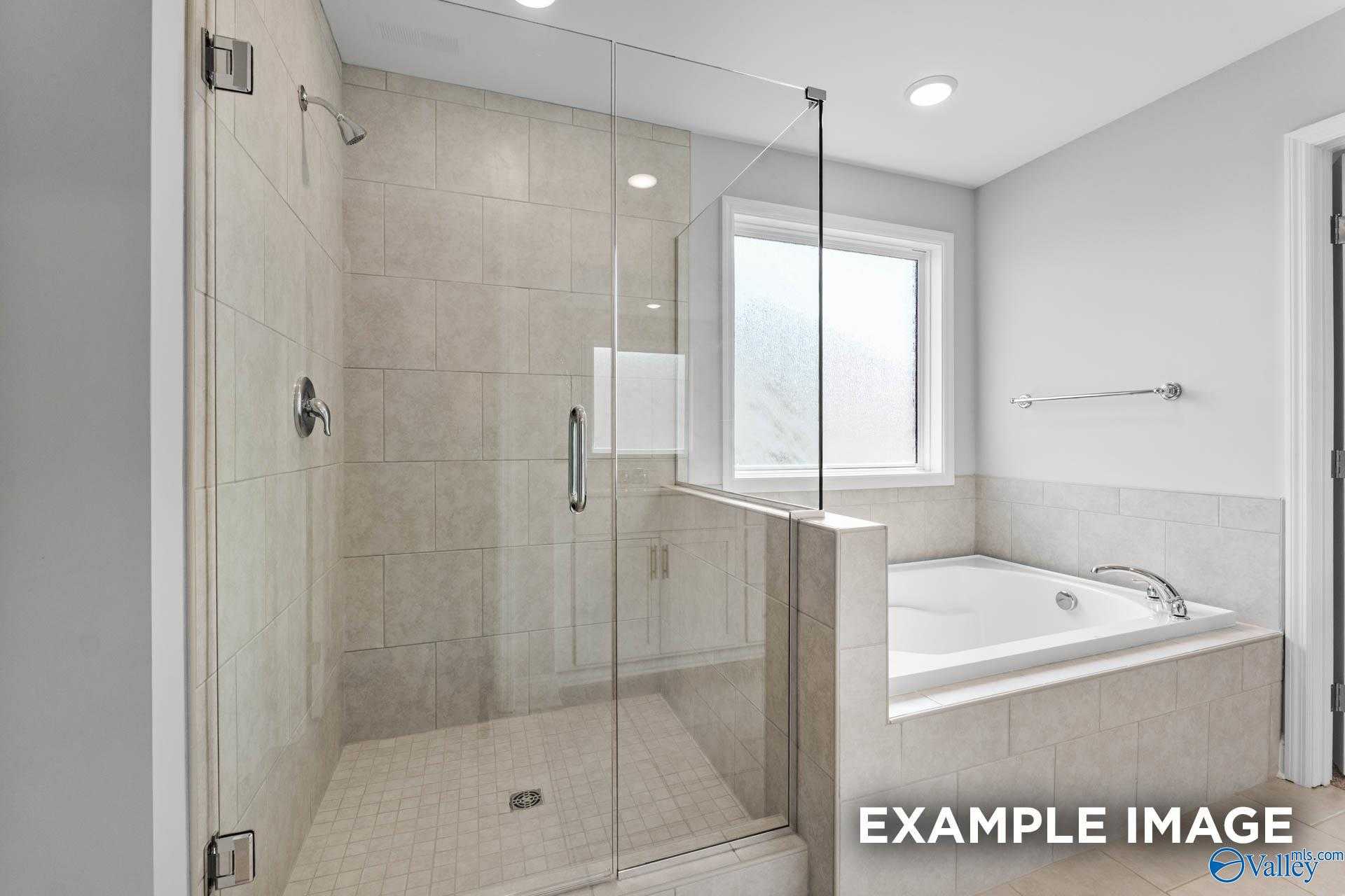 Modern master bathroom with frameless glass shower and soaking tub in Davidson Homes The Madison A, Creekside, Harvest, Alabama