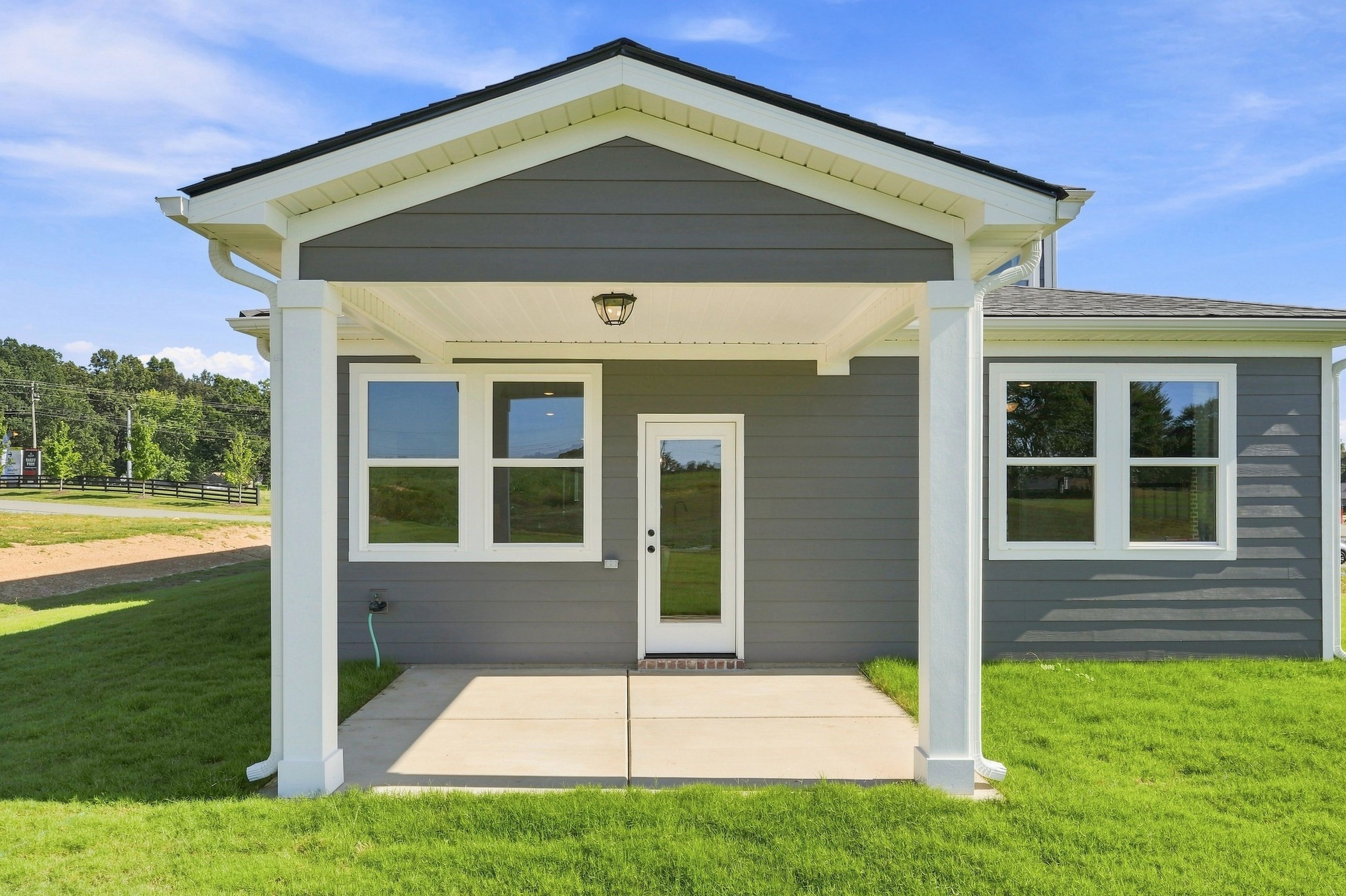 Covered back porch with white columns and concrete patio at Bailey Park by Davidson Homes in Fayetteville, Tennessee