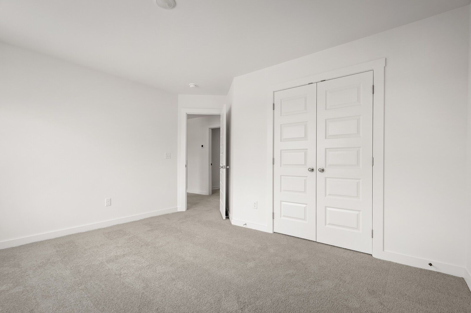 Bright bedroom with plush carpet and double-door closet in The Logan C floor plan at Calista Farms, White House, TN.