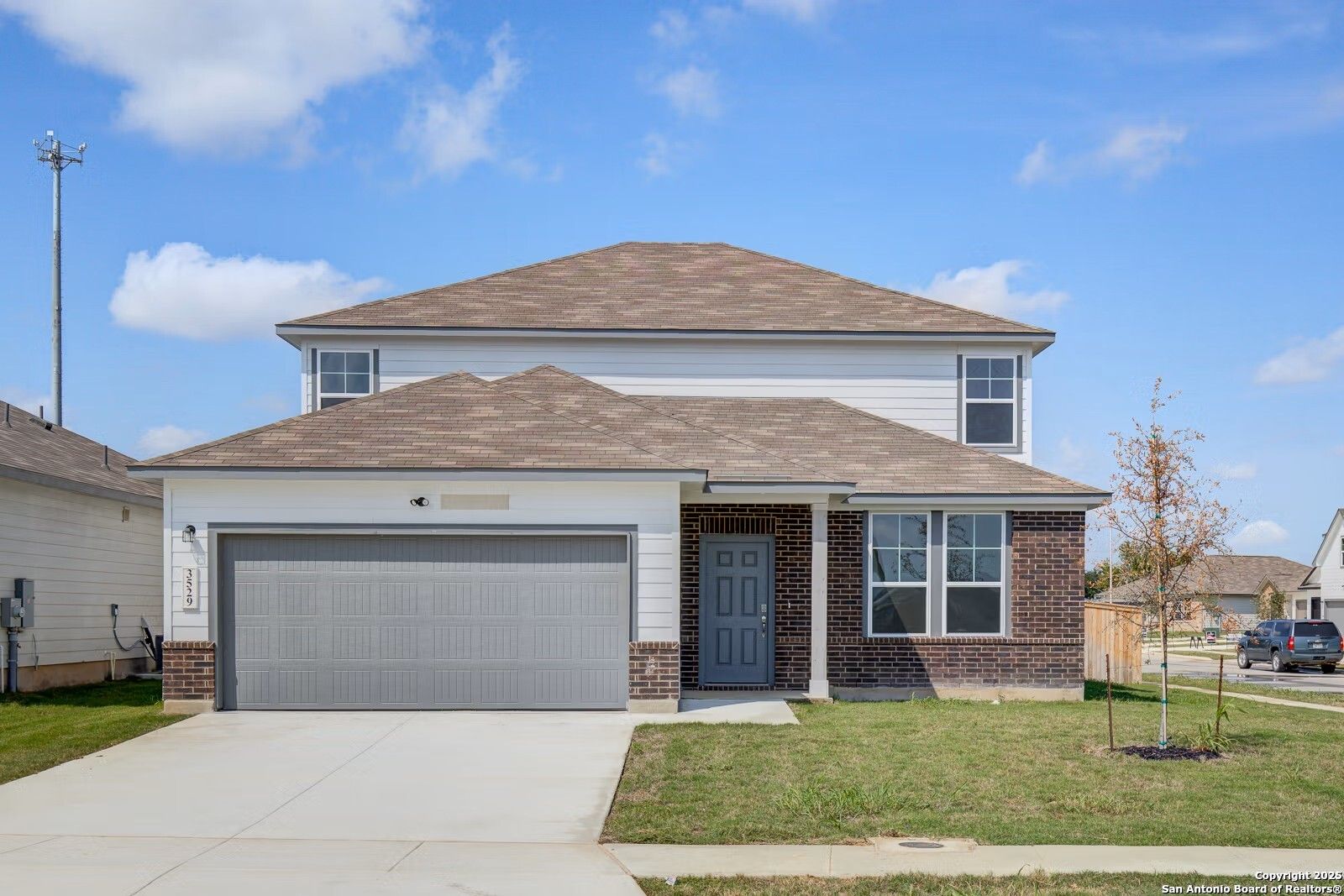 Modern two-story Douglas B home by Davidson Homes with 2-car garage, brick accents, and front lawn in Hannah Heights, Seguin, Texas