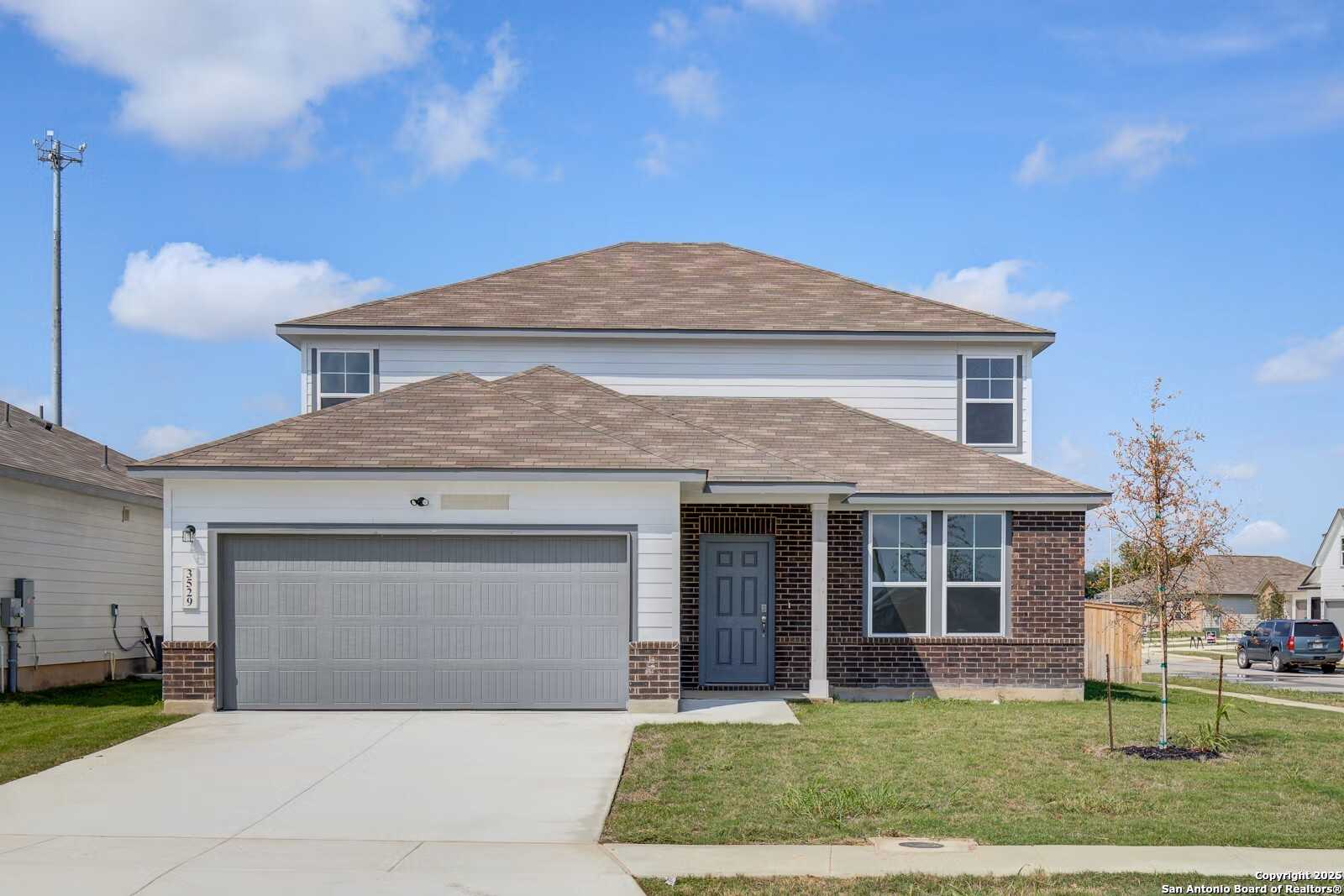 Modern two-story Douglas B home by Davidson Homes with 2-car garage, brick accents, and front lawn in Hannah Heights, Seguin, Texas